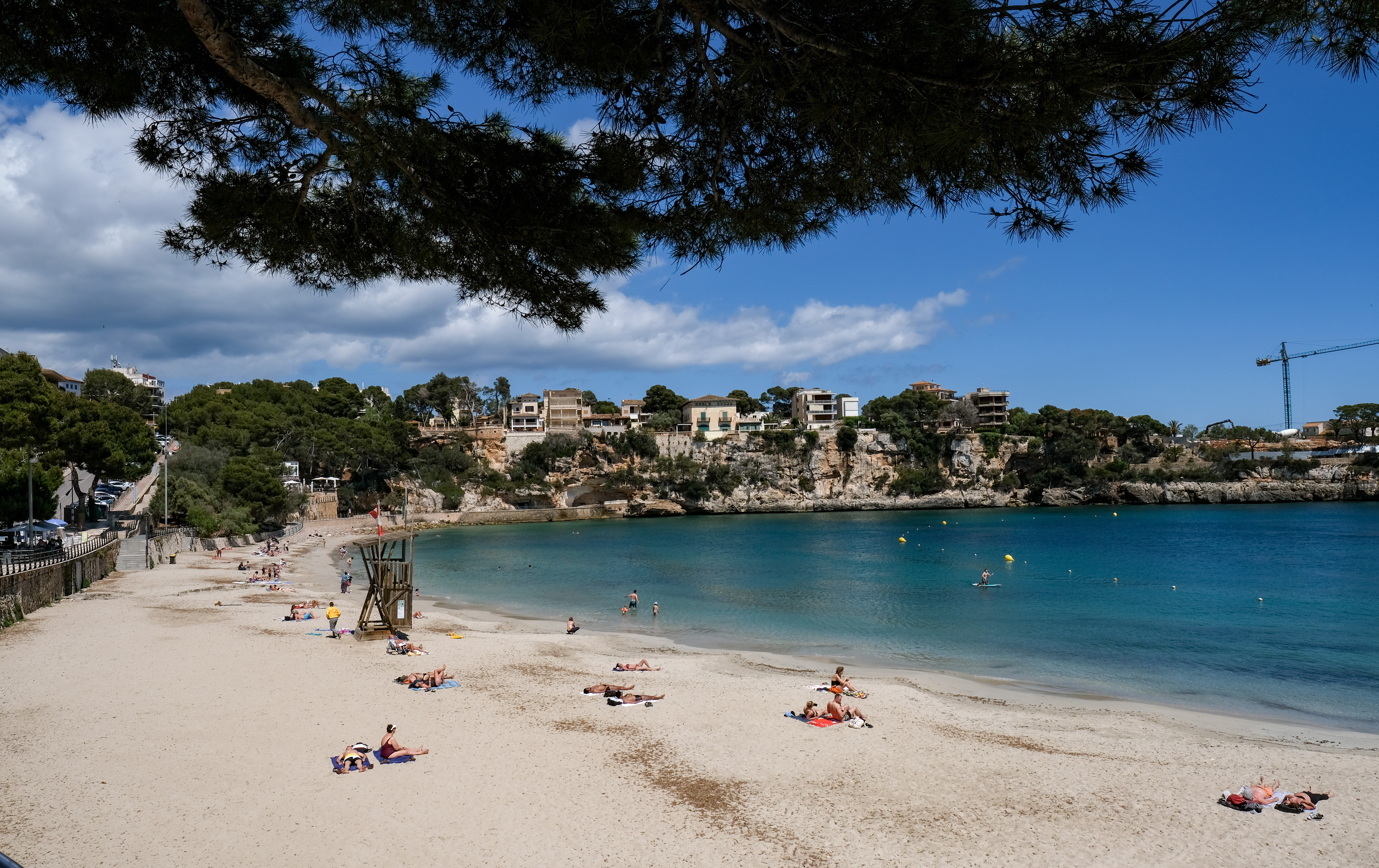 24 May 2021, Spain, Porto Cristo: Few people are seen on the beach of Porto Cristo in the east of the island of Mallorca in sunny weather. Not many tourists have arrived on the island yet.
