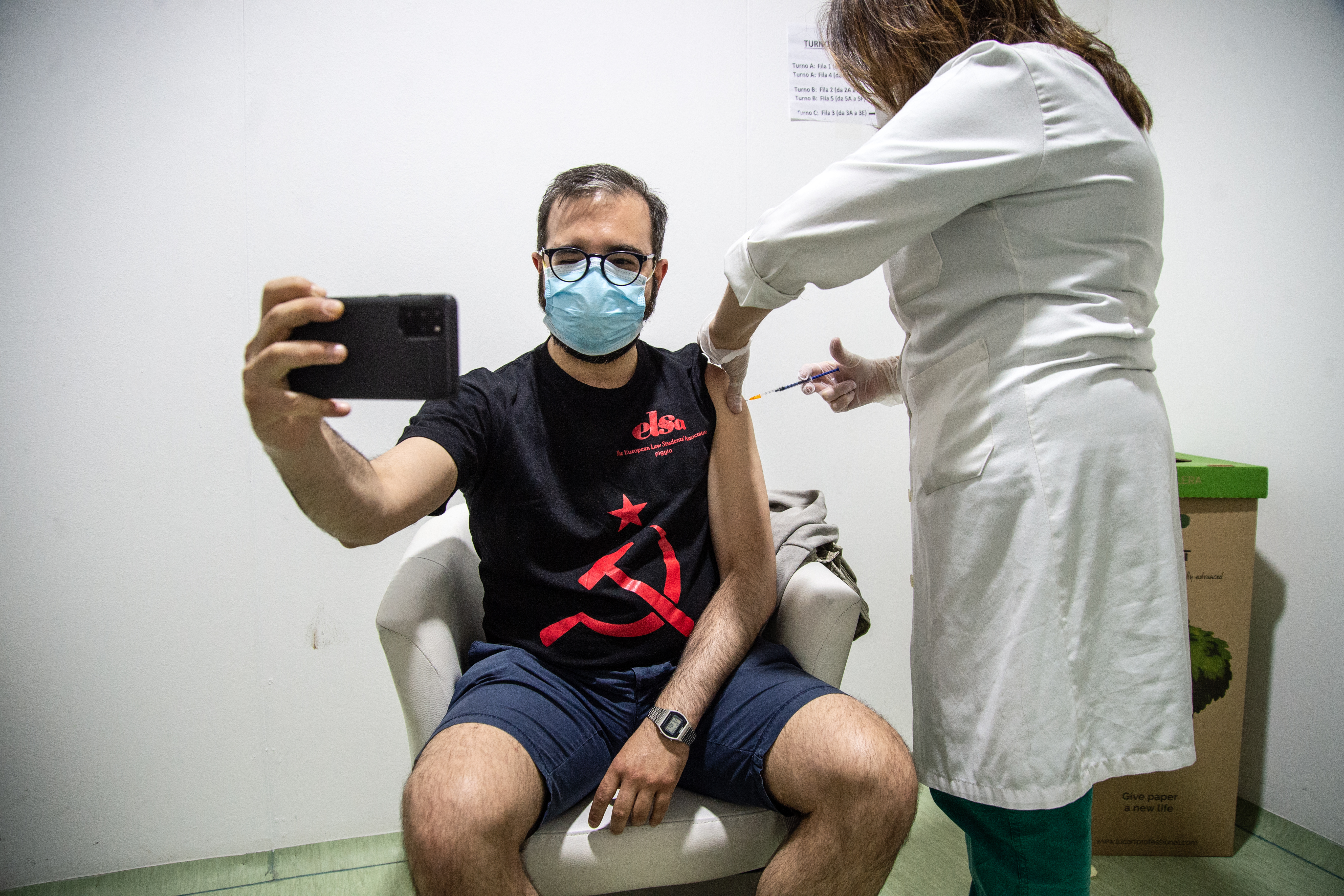 A man takes a selfie as he receives a dose of the Johnson &amp; Johnson's Janssen COVID-19 vaccine at a vaccination center in Naples, Italy. On Friday, U.K. regulators gave the jab the greenlight for use.