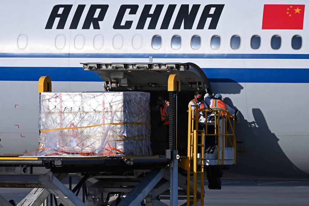 Workers unload the first batch of Chinese Sinovac’s CoronaVac vaccines on arrival at San Oscar Romero International Airport in San Luis Talpa, El Salvador, on March 28, 2021.