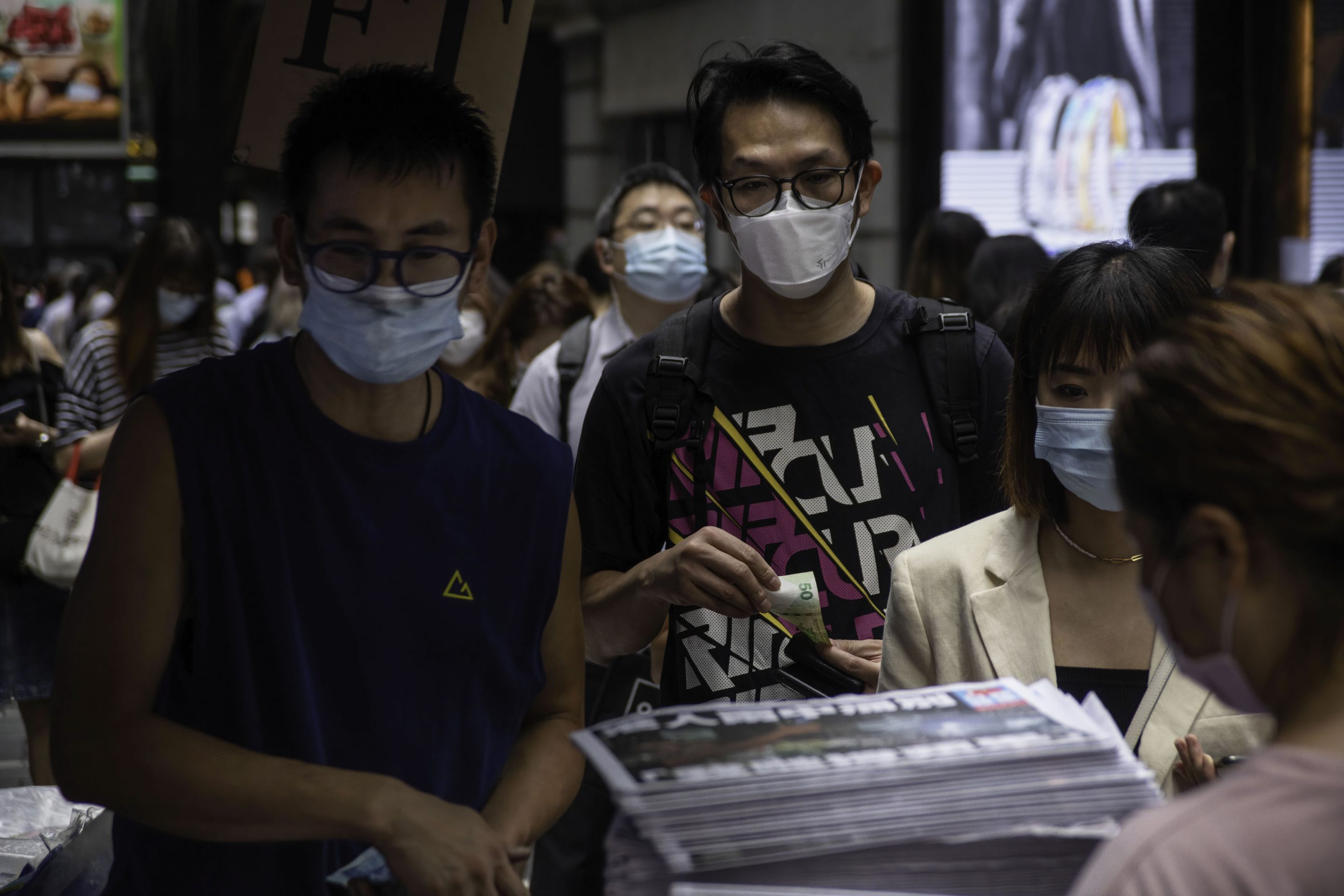 People line up to buy the final edition of the Apple Daily newspaper at a newsstand in Hong Kong's Central District.