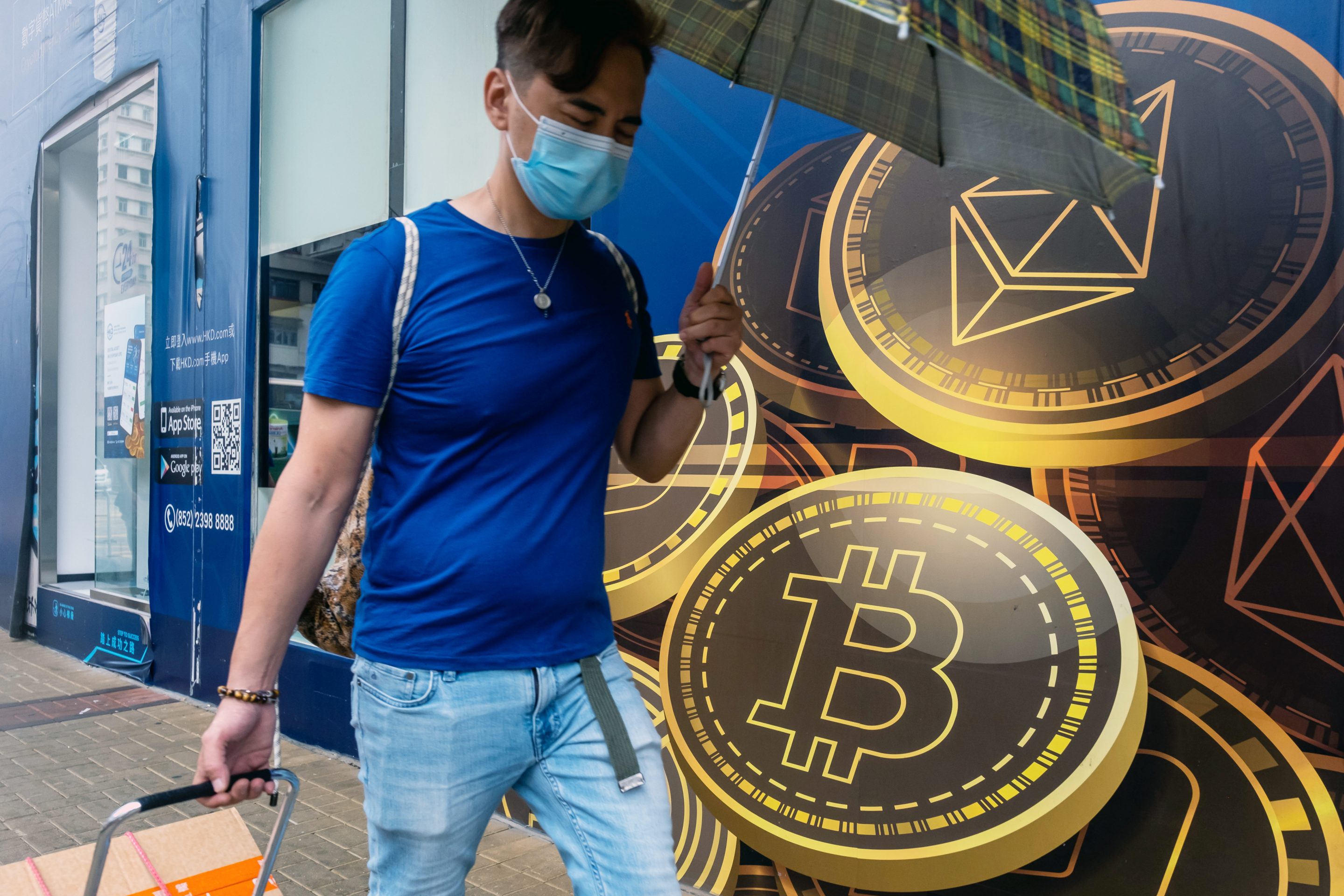 A pedestrian walks past signage for Ethereum and Bitcoin outside the Hong Kong Digital Asset Exchange Ltd. digital currency trading store in Hong Kong, China, on Thursday, June 24, 2021. 