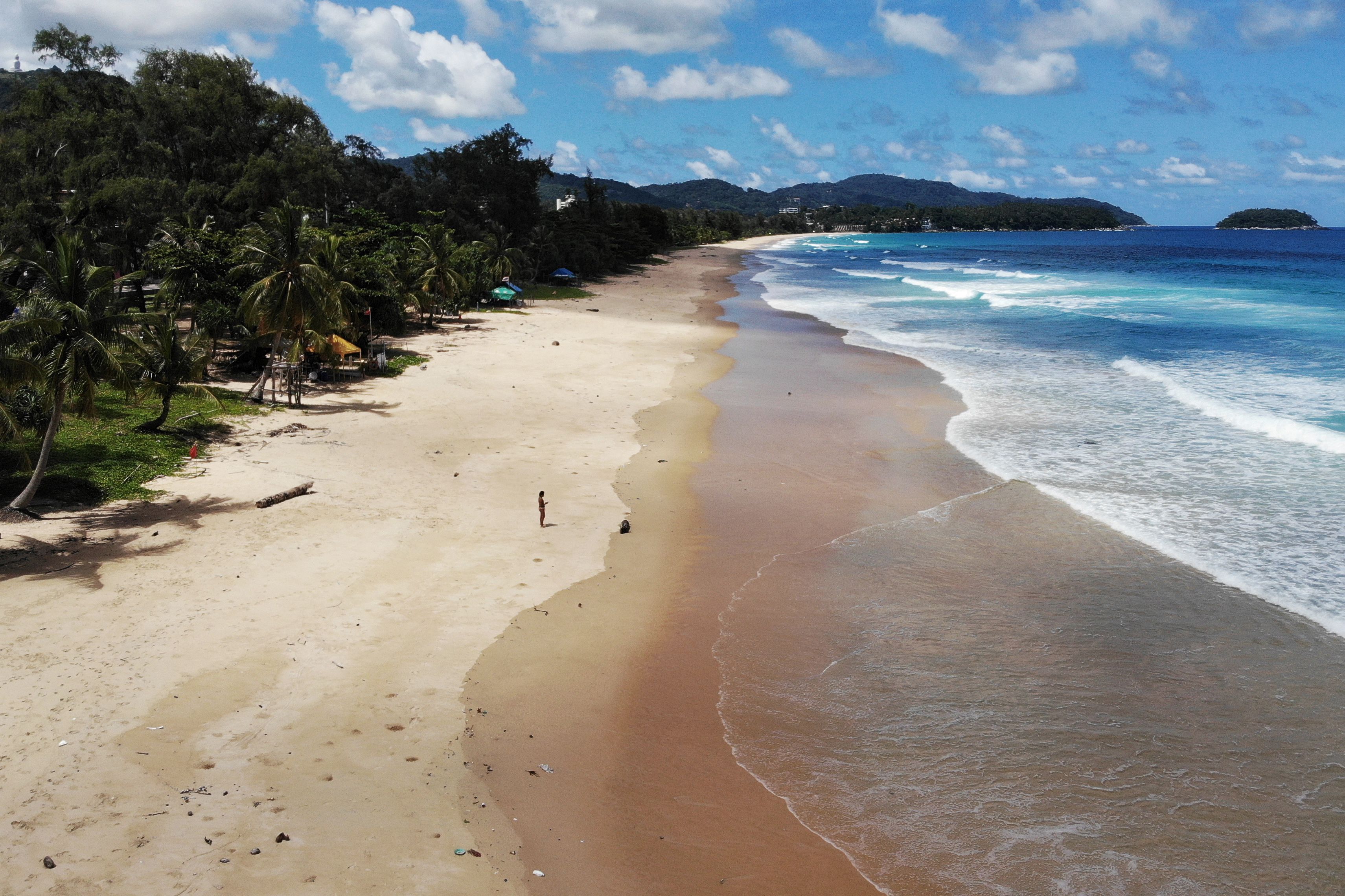 A lone visitor on Karon Beach on June 30, 2021, one day before the Phuket Sandbox tourism scheme that allows visits by people vaccinated against the Covid-19 coronavirus is set to launch.