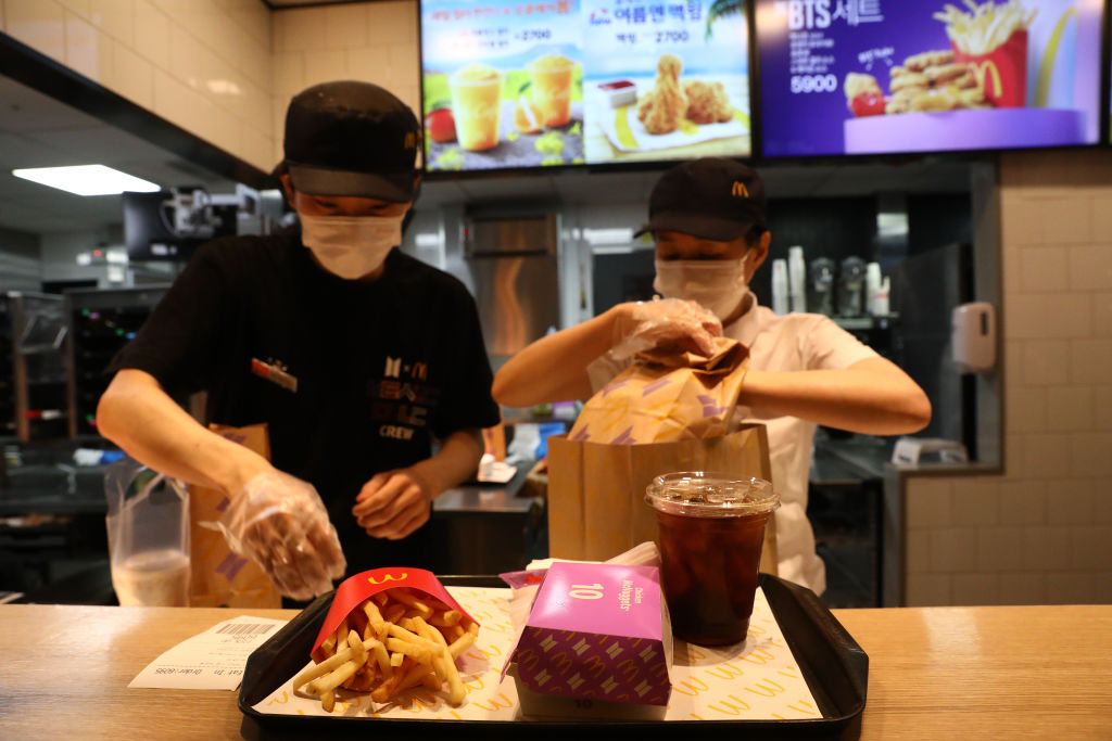 McDonald’s employees serve a BTS Meal on May 27, 2021, in Seoul. The meal will be available in 49 countries.