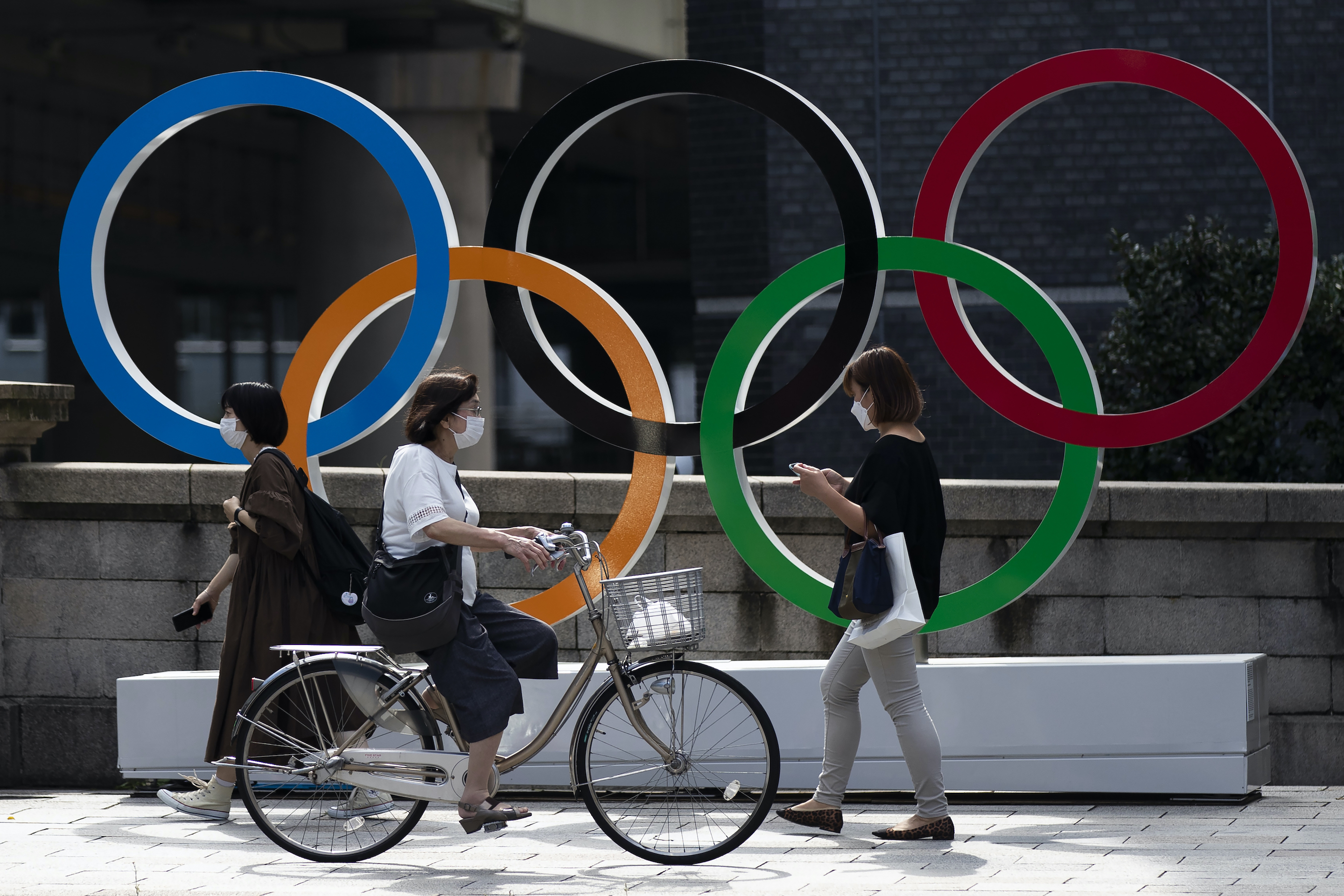 People walk by the Olympic rings installed by the Nippon Bashi bridge in Tokyo.
