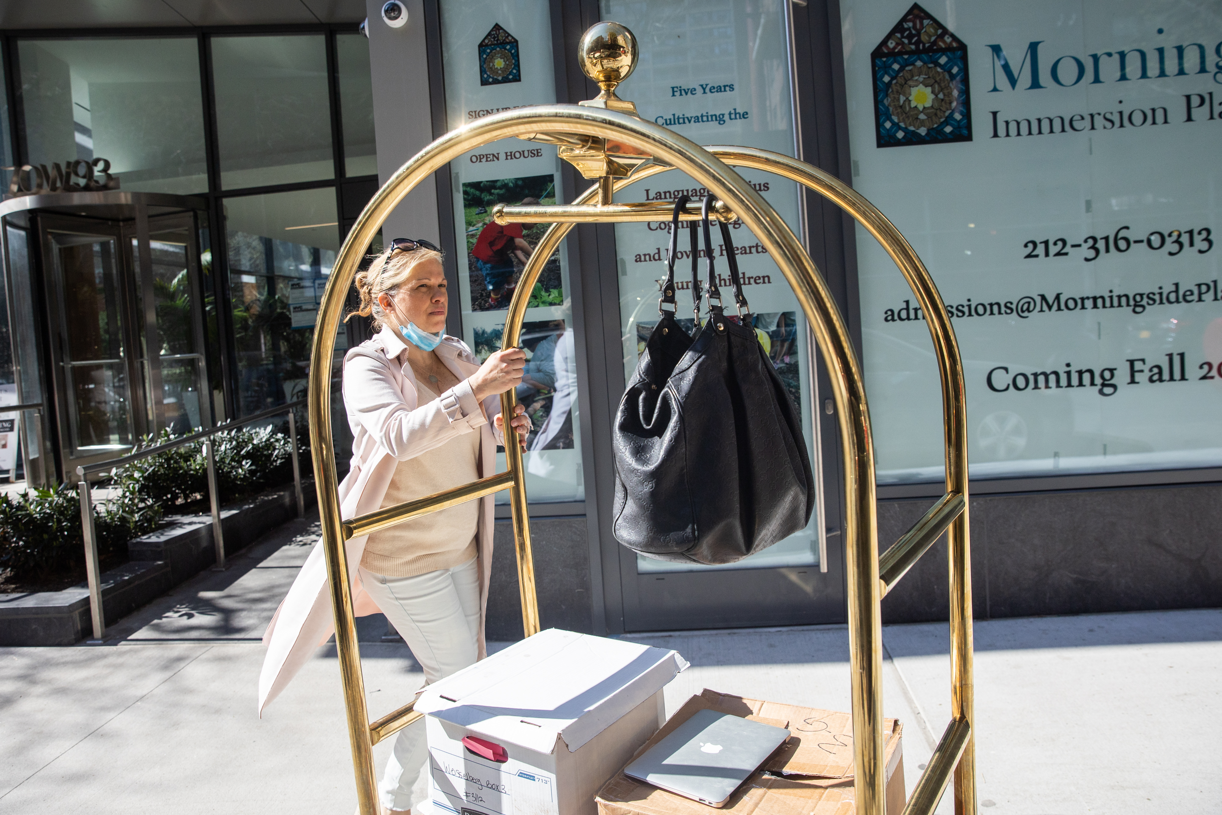 Trump Organization CFO's ex-daughter-in-law Jennifer Weisselberg carries boxes of documents and a laptop to prosecutors outside her apartment in Manhattan, New York on April 8, 2021.