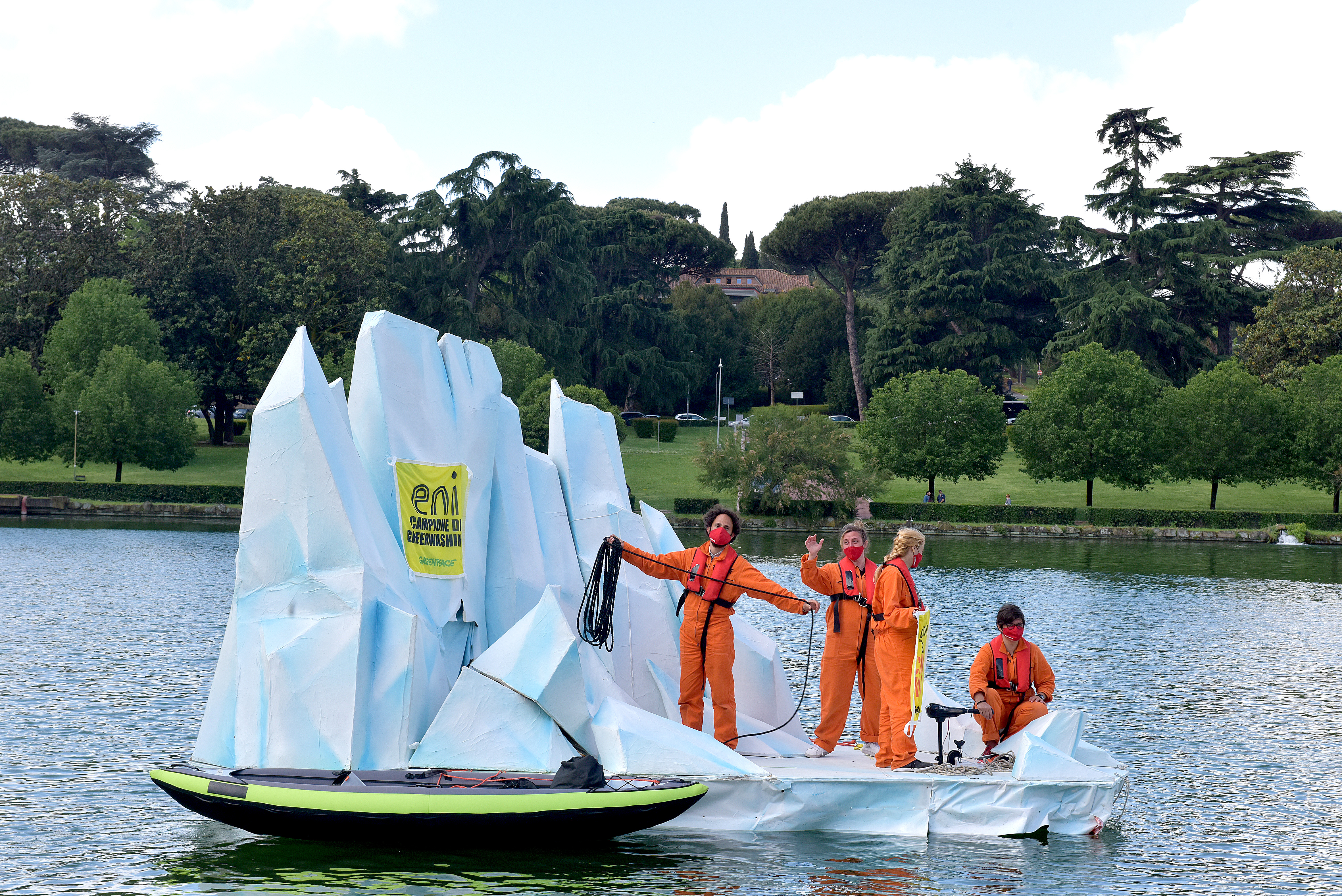 Greenpeace activists with a floating replica of an iceberg melting into the lake in front of ENI's headquarters, during ENI's shareholders' meeting, to witness the dramatic impacts of the climate emergency on the planet, with banners reading greenwashing is a climate killer, on May 12, 2021 in Rome, Italy. Activists from Extinction Rebellion Italia (XR) and Greenpeace demand ENI shareholders a definitive elimination of fossil fuels from ENI's energy plans.