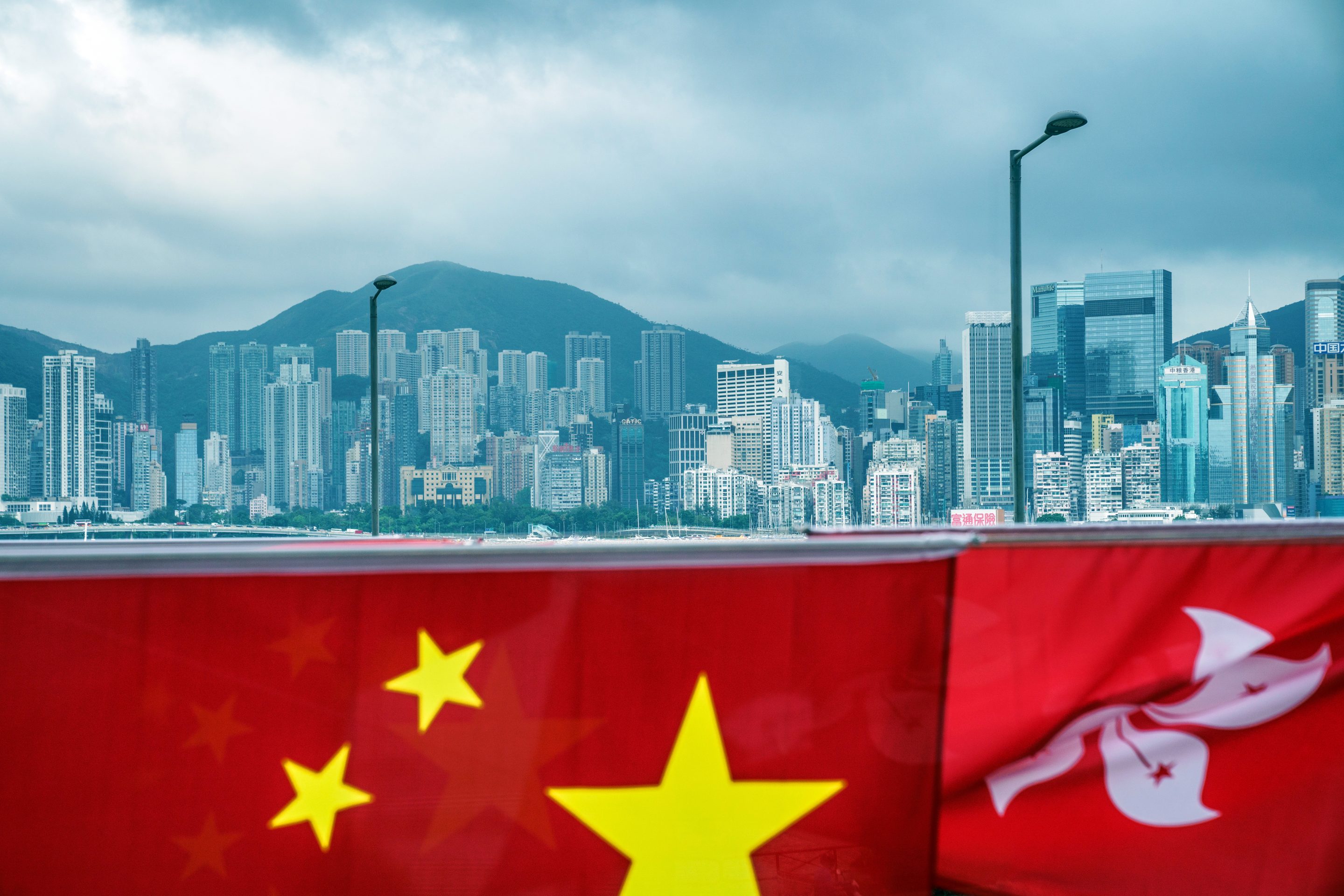 The flags of China, left, and the Hong Kong Special Administrative Region (HKSAR) against the city's skyline ahead of the anniversary of Hong Kong's return to China in Hong Kong, China, on Wednesday, June 30, 2021.