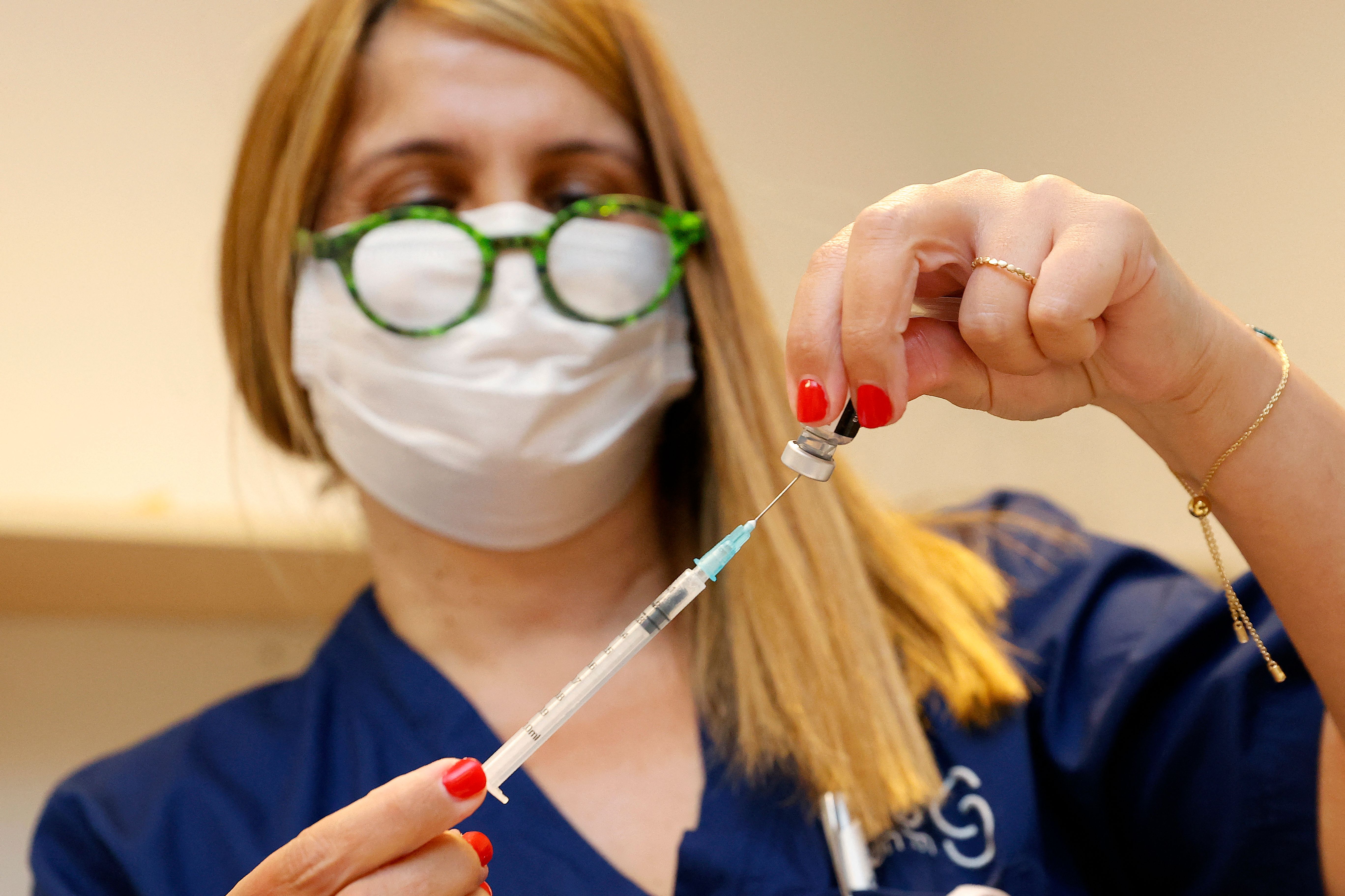 A medical worker prepares a shot of the Pfizer-BioNTech COVID-19 coronavirus vaccine to be administered as a third dose, at the outpatient clinics of the Cardiovascular Centre at Sheba Medical Center near Tel Aviv, Israel, on July 12, 2021.