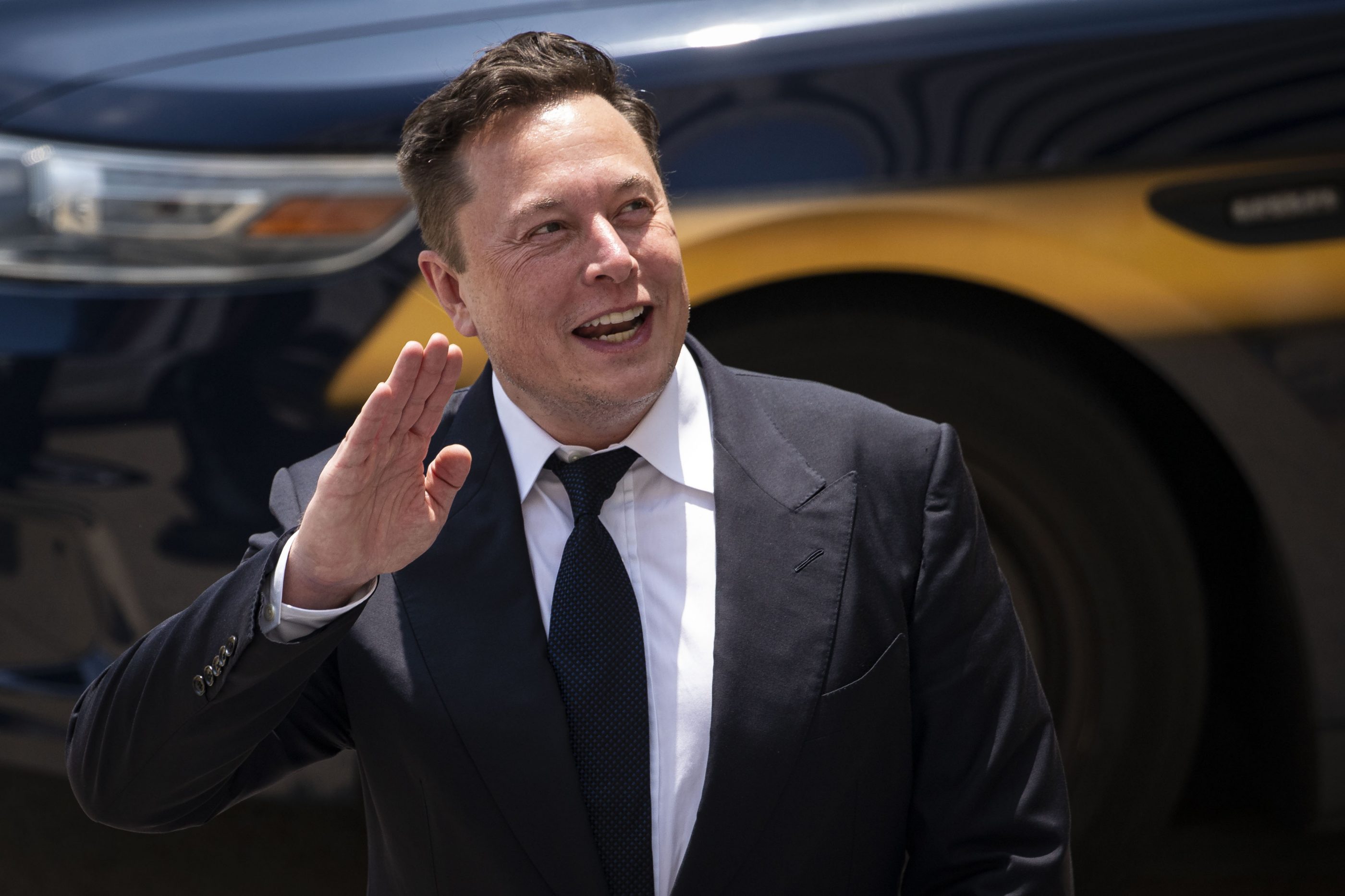 Tesla CEO Elon Musk waves while departing court during the SolarCity trial in Wilmington, Del., on July 13, 2021.