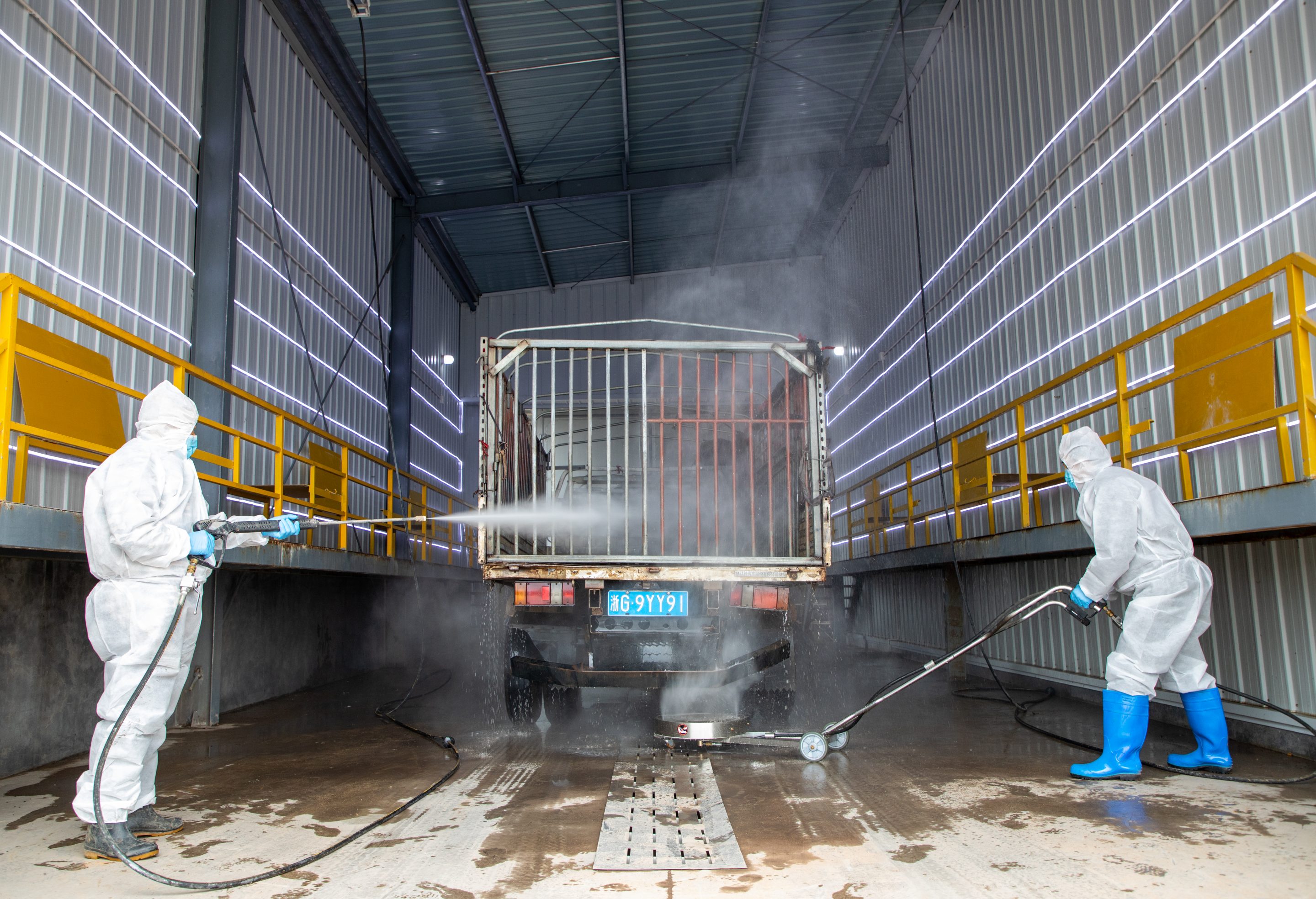 Officers from a local agriculture and rural affairs bureau disinfect a truck at an animal quarantine station on Feb. 3, 2021, in Jinhua, Zhejiang province, China.