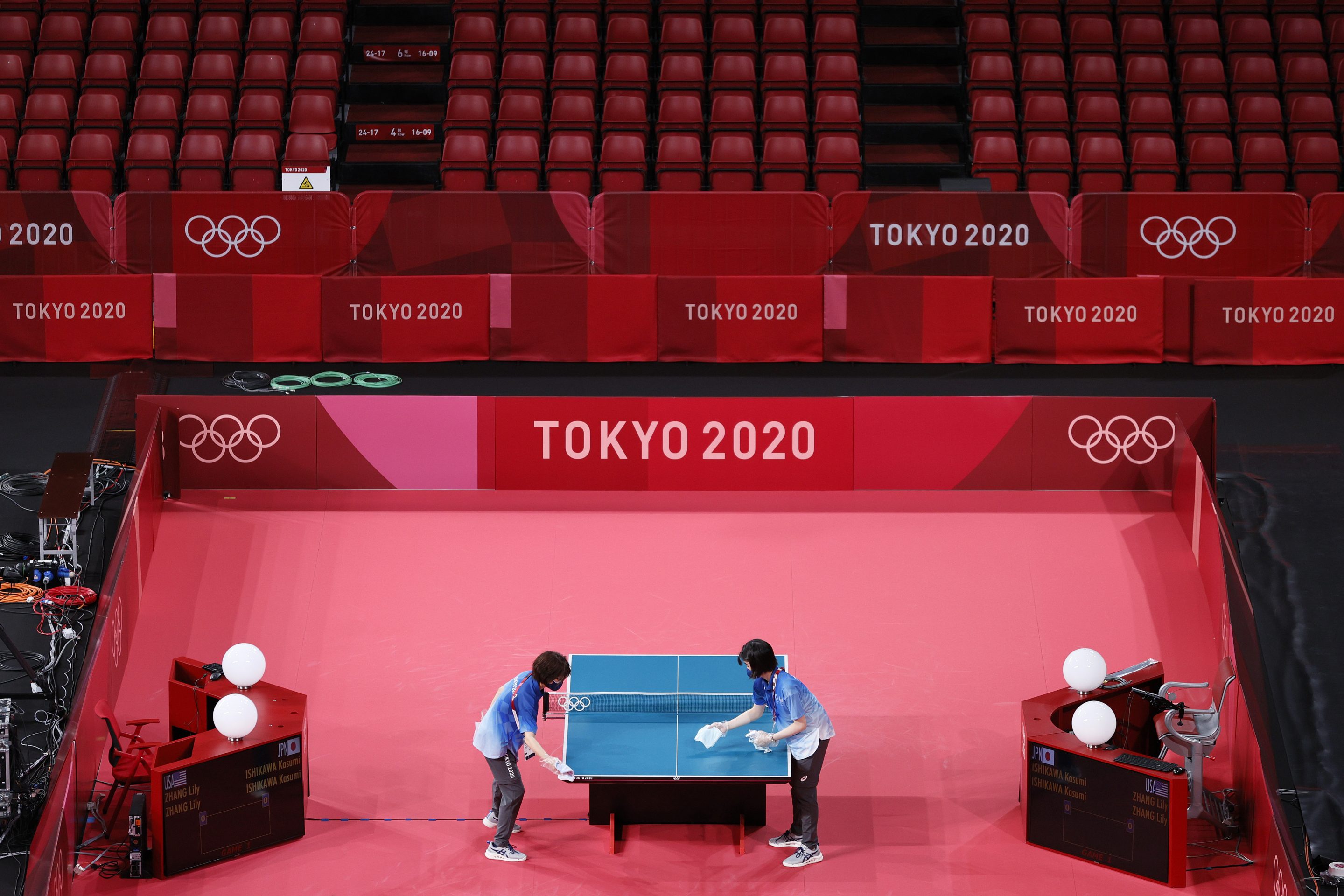 Workers disinfect a table tennis court ahead of the Tokyo 2020 Olympic Games at Tokyo Metropolitan Gymnasium on July 21, 2021 in Tokyo, Japan. 