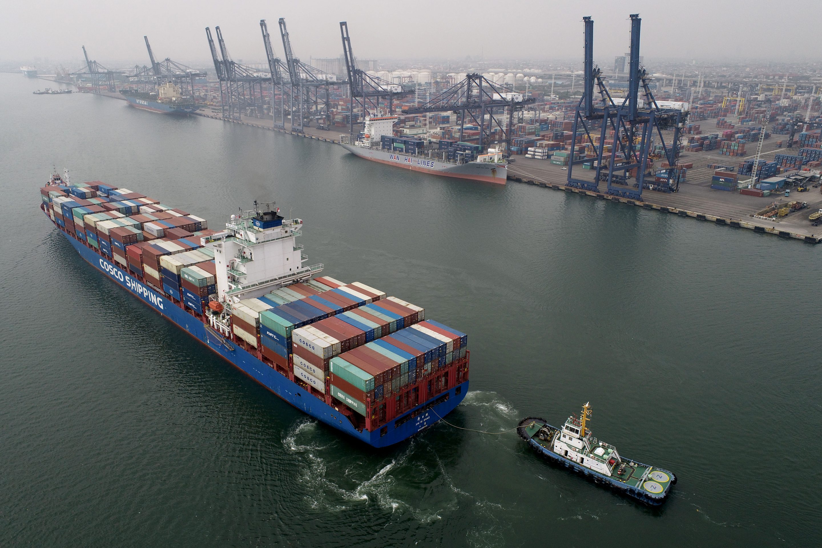 A tug boat guides the Xin Ri Zhao container ship into Tanjung Priok Port in Jakarta, Indonesia, on Tuesday, July 13, 2021. Indonesia will release trade figures on July 15. Photographer: Dimas Ardian/Bloomberg via Getty Images