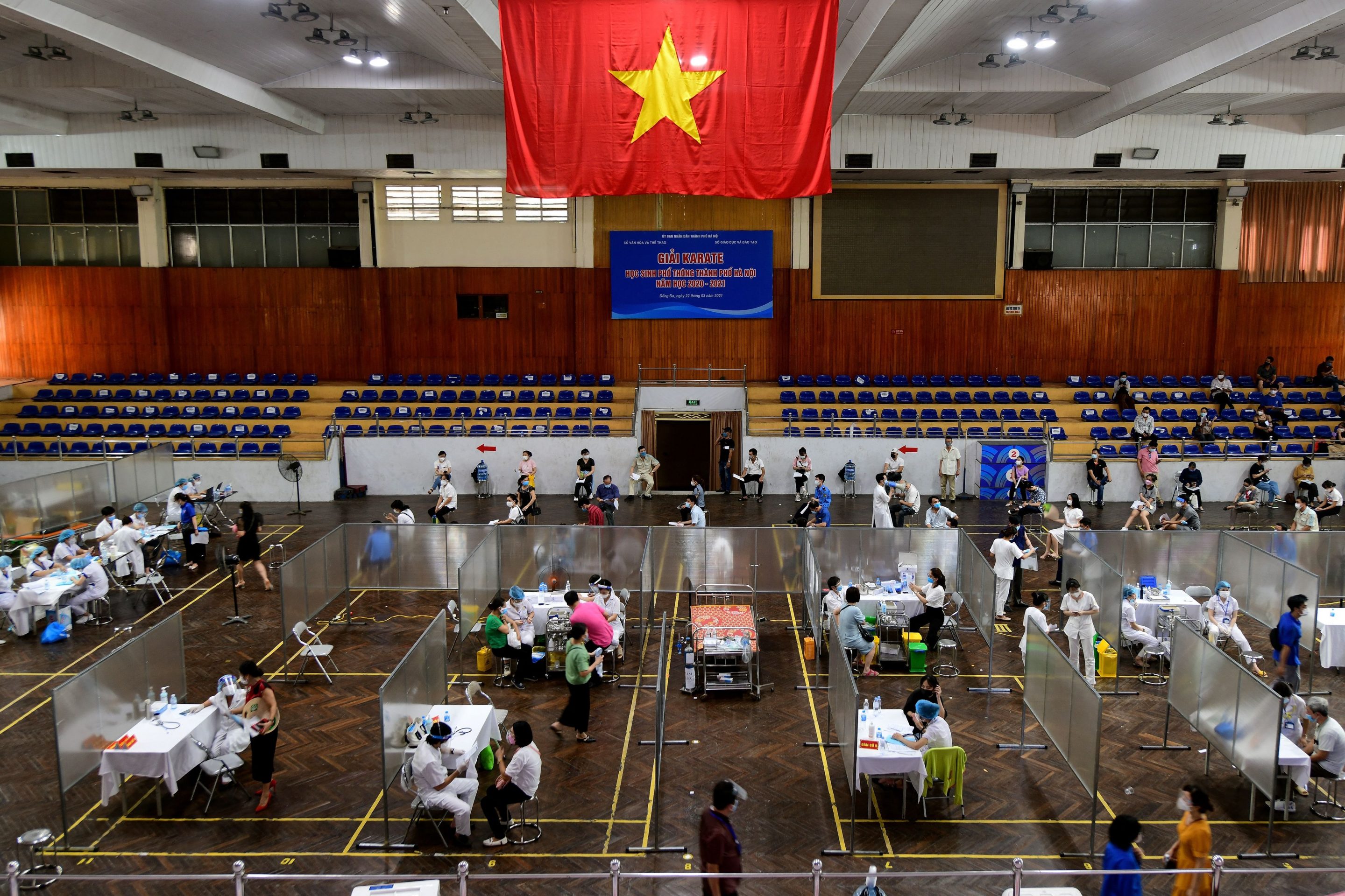 People receive the AstraZeneca COVID-19 coronavirus vaccine at the Trinh Hoai Duc Indoor stadium in Hanoi on August 2, 2021.