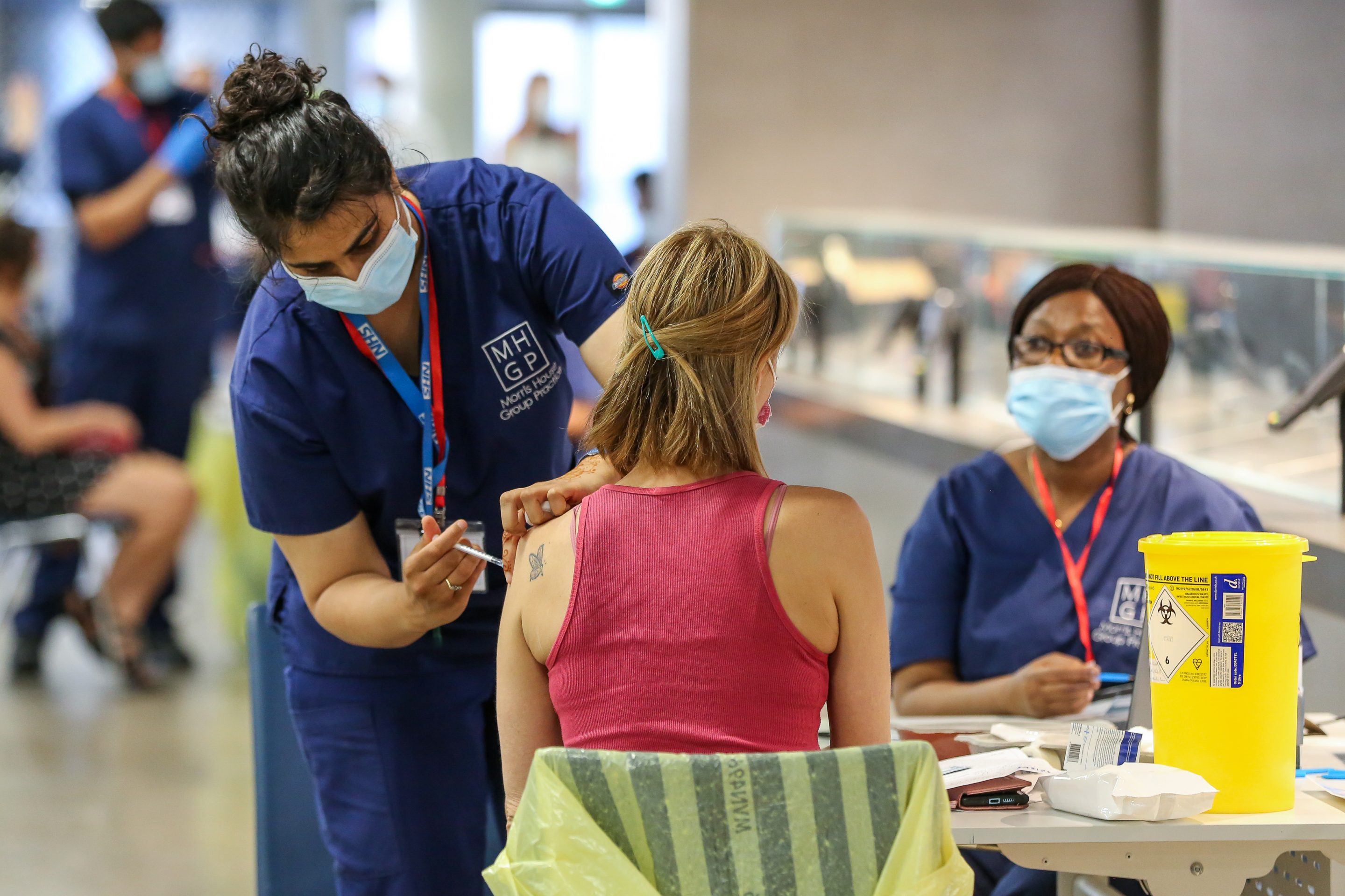 A NHS health worker administers a dose of Pfizer Covid-19 vaccine to woman at Tottenham Hotspur Stadium in north London as UK COVID-19 vaccination drive continues.