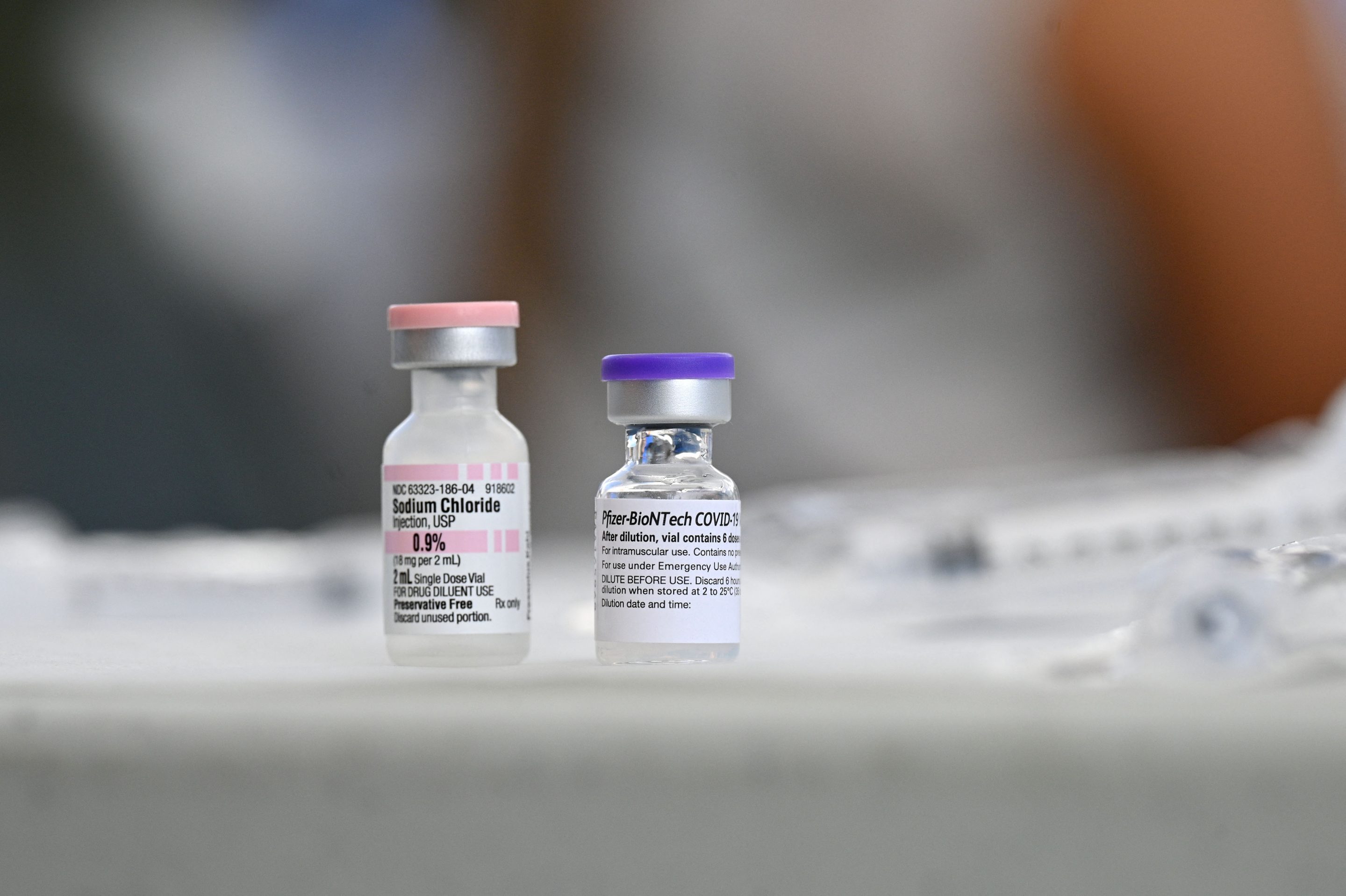 Vials of Pfizer COVID-19 vaccine and sodium cloride (used for dilution of the vaccine) are seen at a community vaccination event in a predominately Latino neighborhood in Los Angeles, California, August 11, 2021.