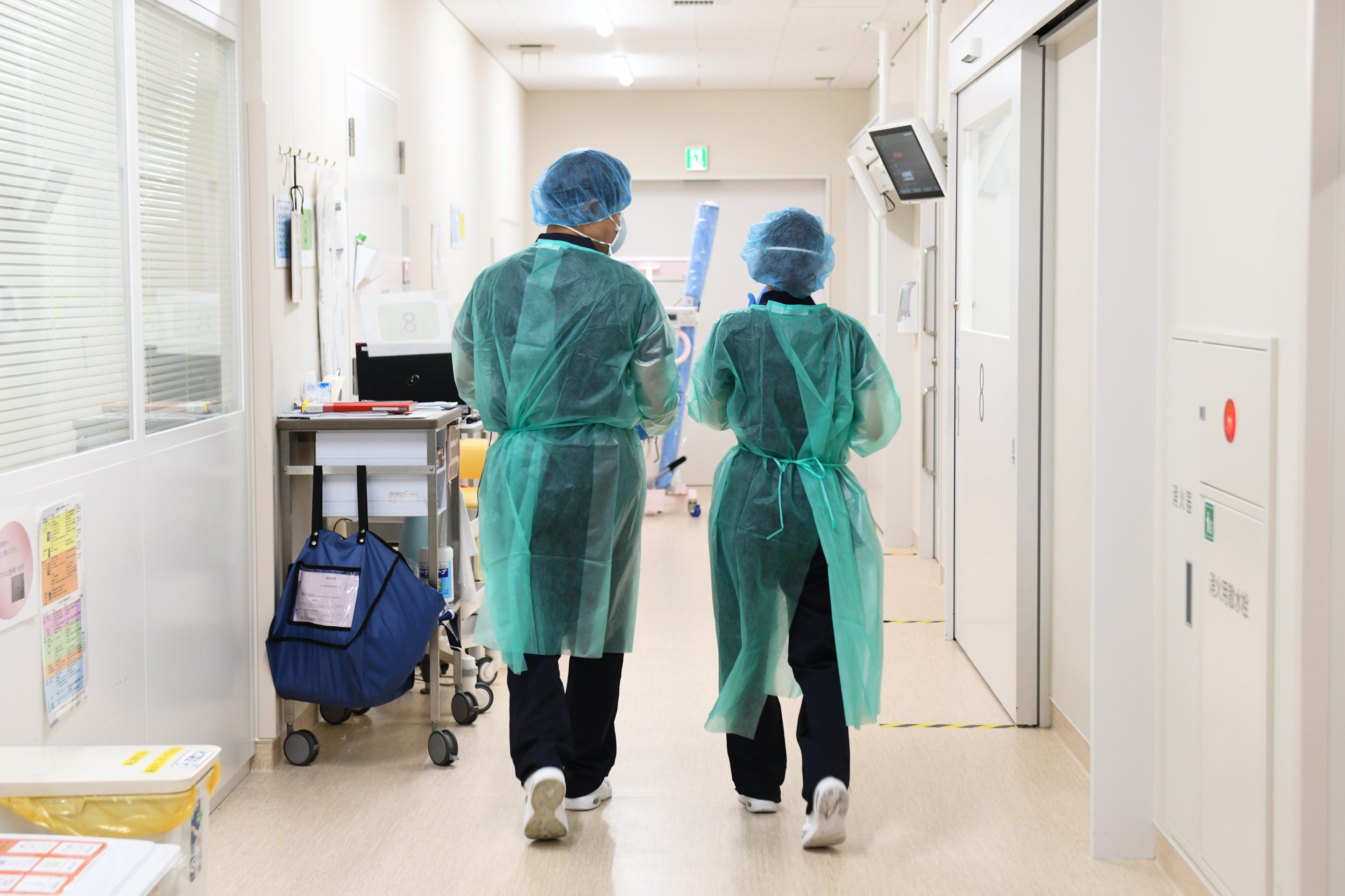 Healthcare workers walk through a hallway at the intensive care unit (ICU) at Chiba University Hospital in Chiba, Chiba Prefecture, Japan, on Wednesday, Aug. 25, 2021.