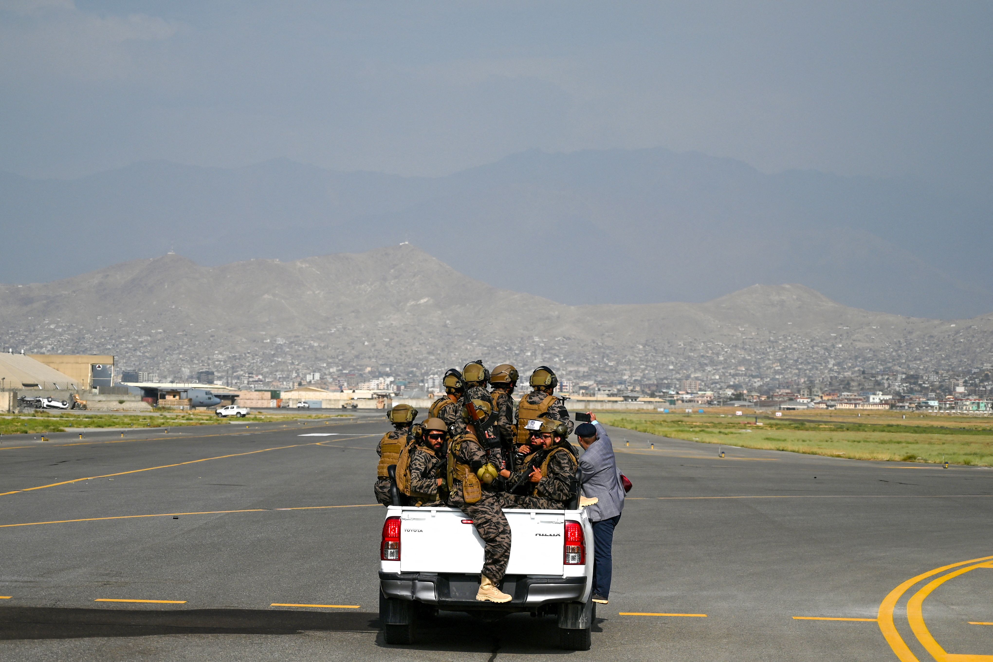Members of the Taliban Badri 313 military unit ride a vehicle on the runway of the airport in Kabul on August 31, 2021