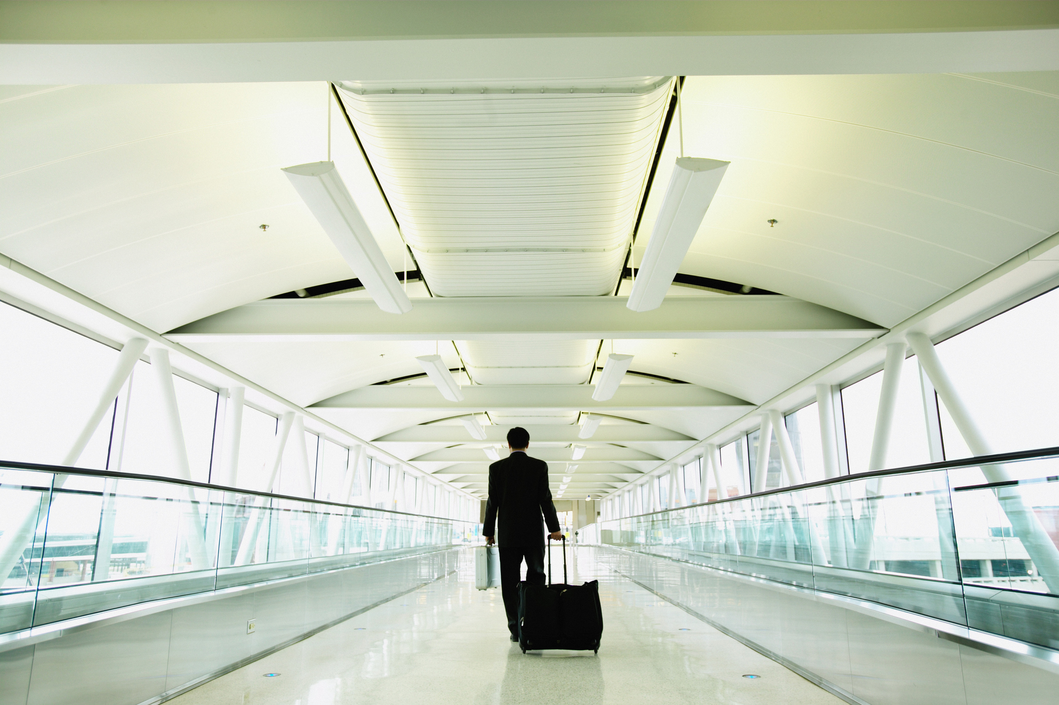 A businessman on motorized walkway at Baltimore/Washington International Thurgood Marshall Airport.
