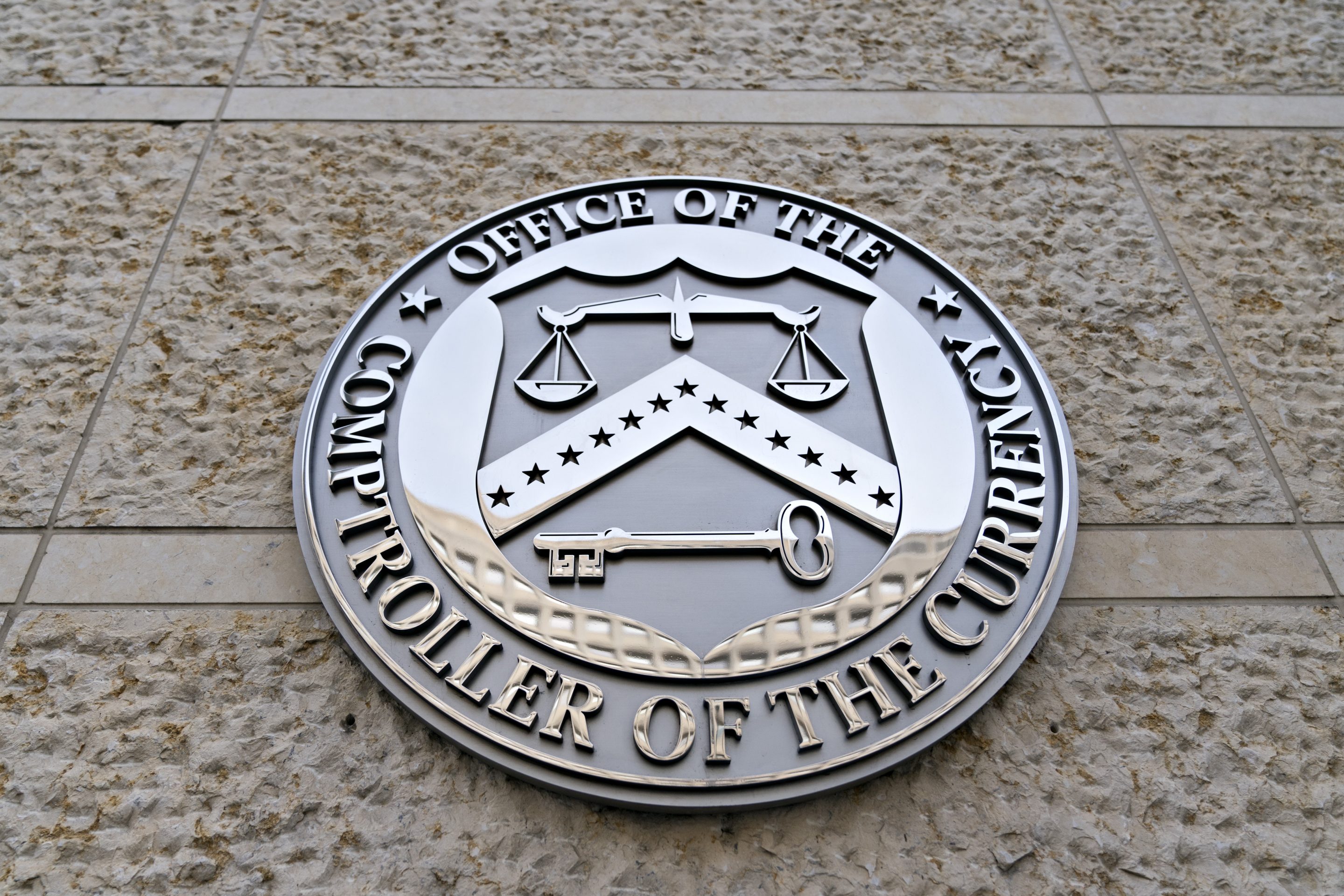 The seal of the Office of the Comptroller of the Currency (OCC) is displayed outside the organization's headquarters in Washington, D.C. on March 20, 2019.