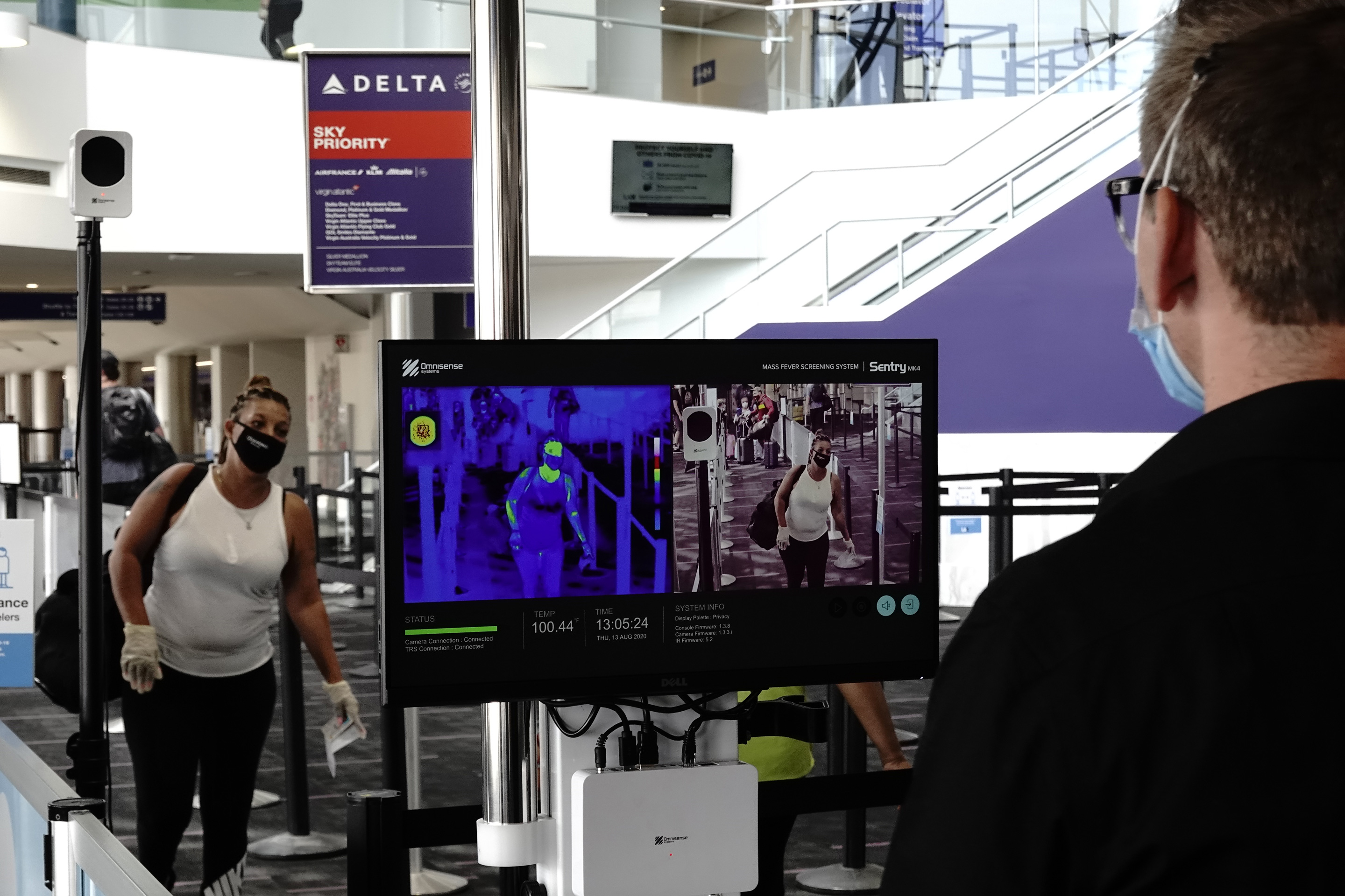 A traveler approaches an Omnisense Systems thermal imaging camera inside Terminal 2 at Los Angeles International Airport, on Aug. 13, 2020.