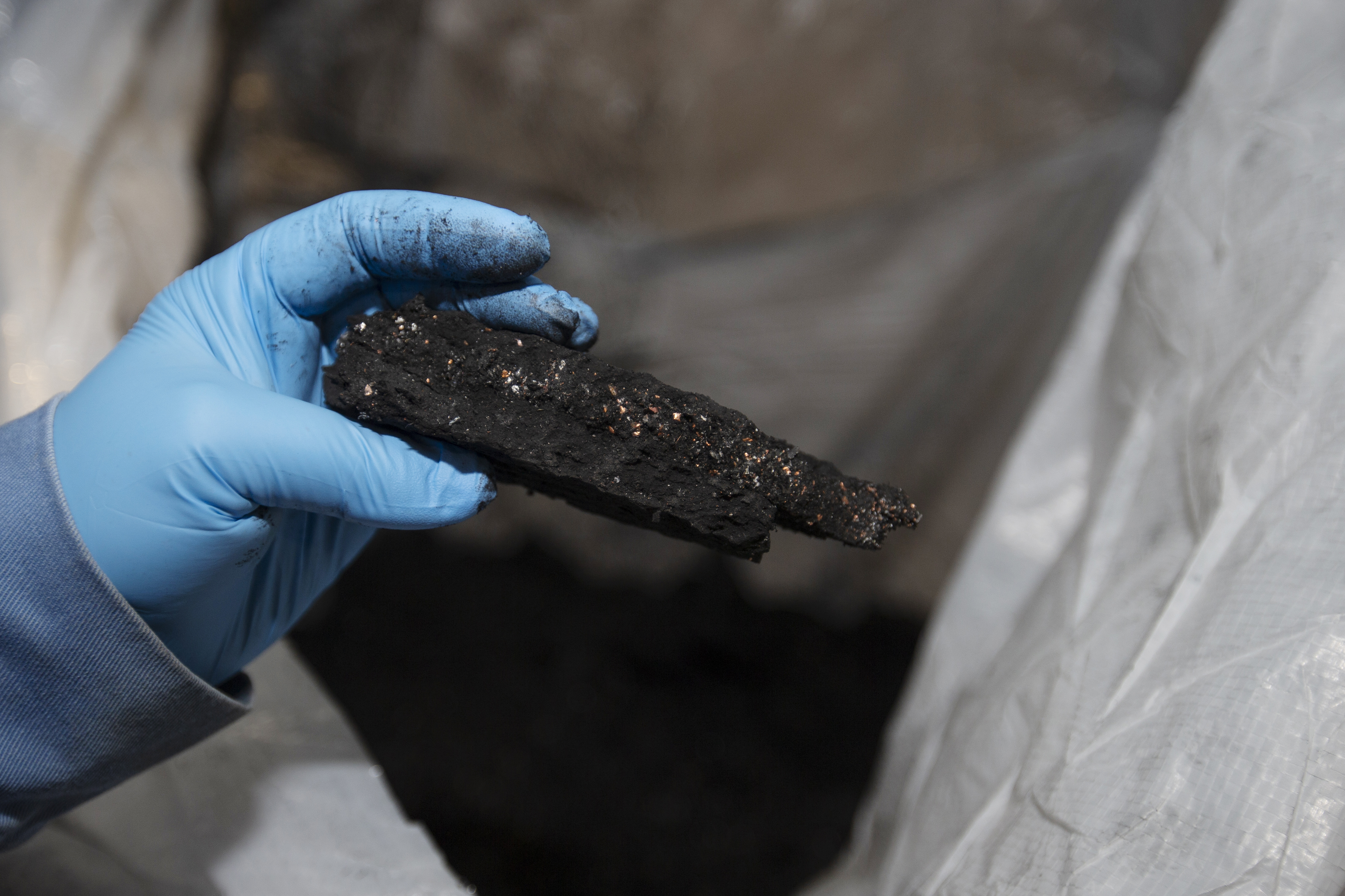 A worker holds a piece of black mass, a mix of lithium, nickel, cobalt, and graphite, at the Li-Cycle lithium-ion battery recycling facility in Kingston, Ontario, Canada, on Feb. 19, 2021. Li-Cycle is a Redwood Materials competitor.