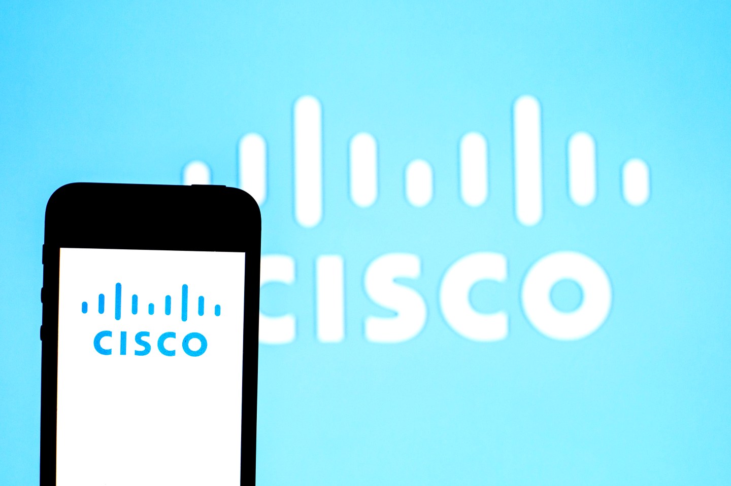 In this photo illustration a Cisco Systems logo seen displayed on a smartphone with a Cisco Systems logo in the background.