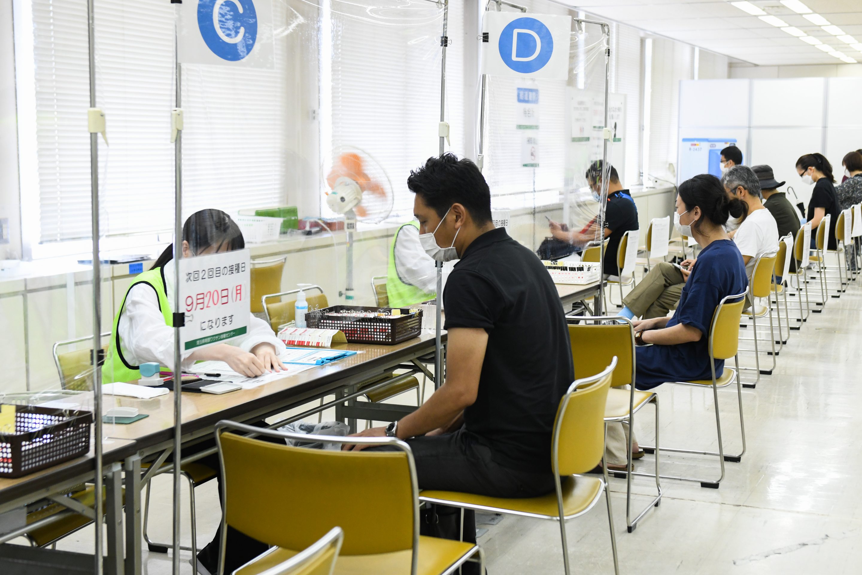 Residents get a consultation after receiving the Moderna Inc. COVID-19 vaccine at a mass vaccination site in Saitama City, Saitama, Japan, on Monday, Aug. 23, 2021.