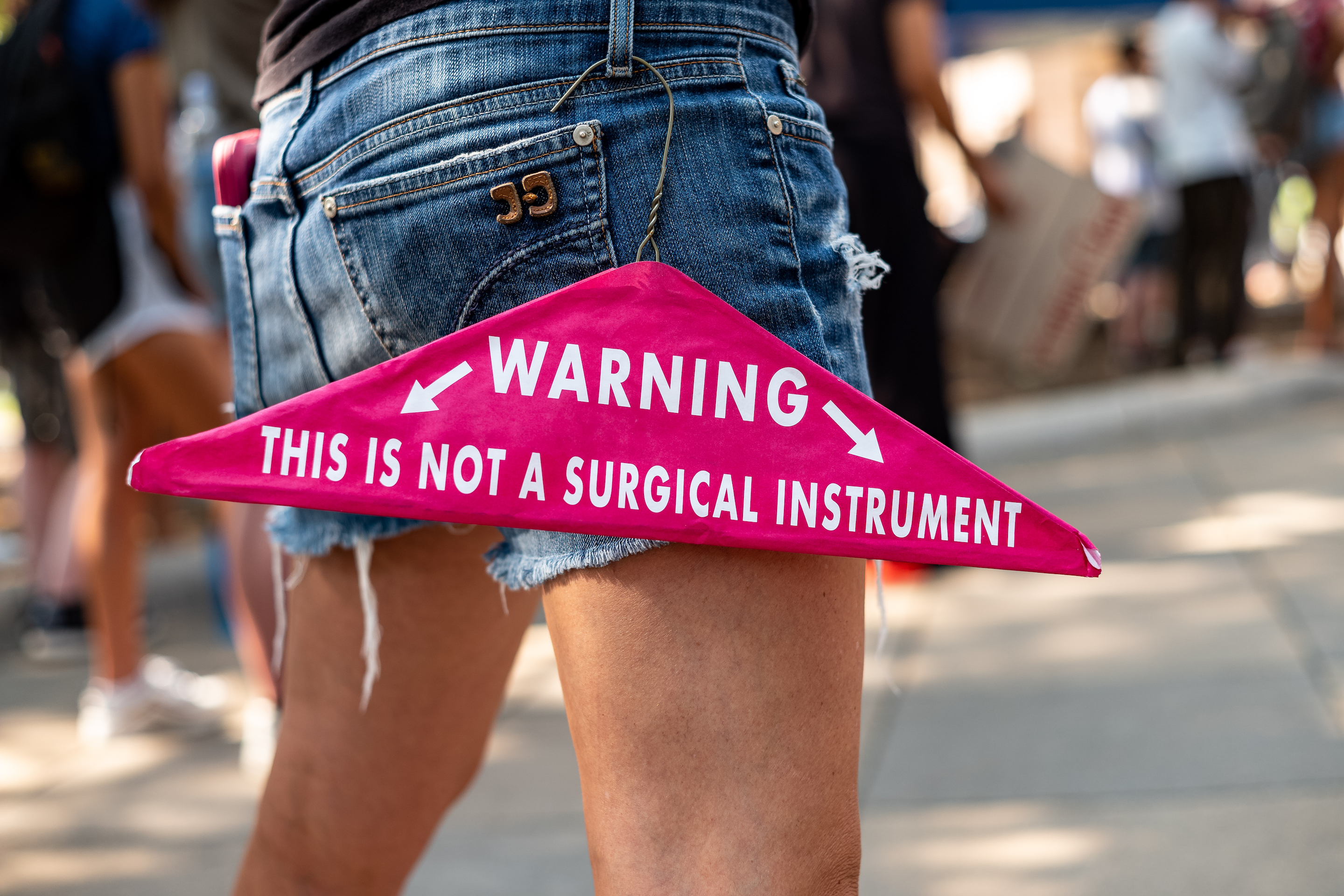 An Abortion rights activist carries a clothes hanger with the worlds “this is not a surgical instrument,” at a rally at the Texas State Capitol on September 11, 2021 in Austin, Texas.