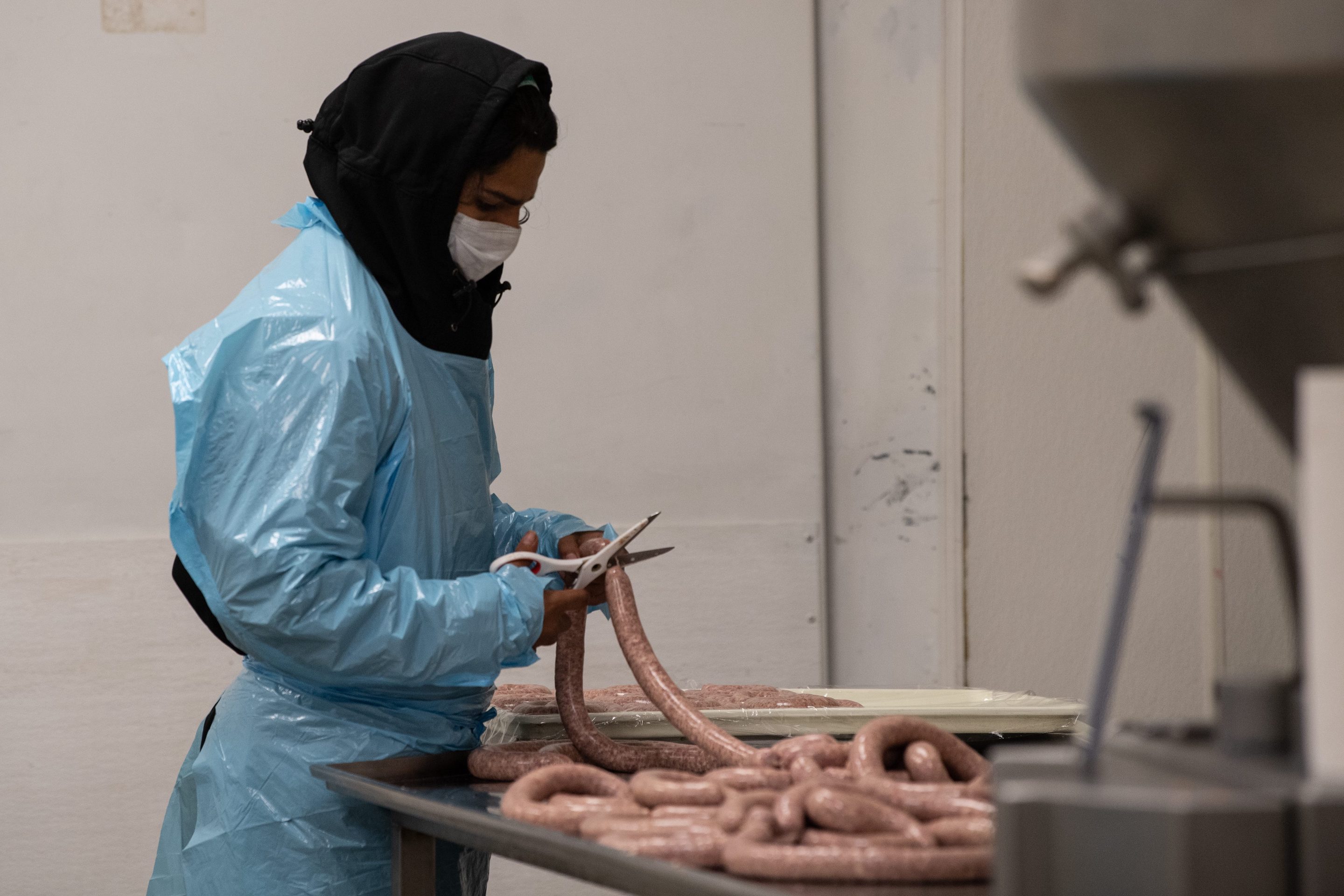 An employee cuts sausage at Jamie Stachowski's factory in Capitol Heights, Maryland, on May 6, 2020.