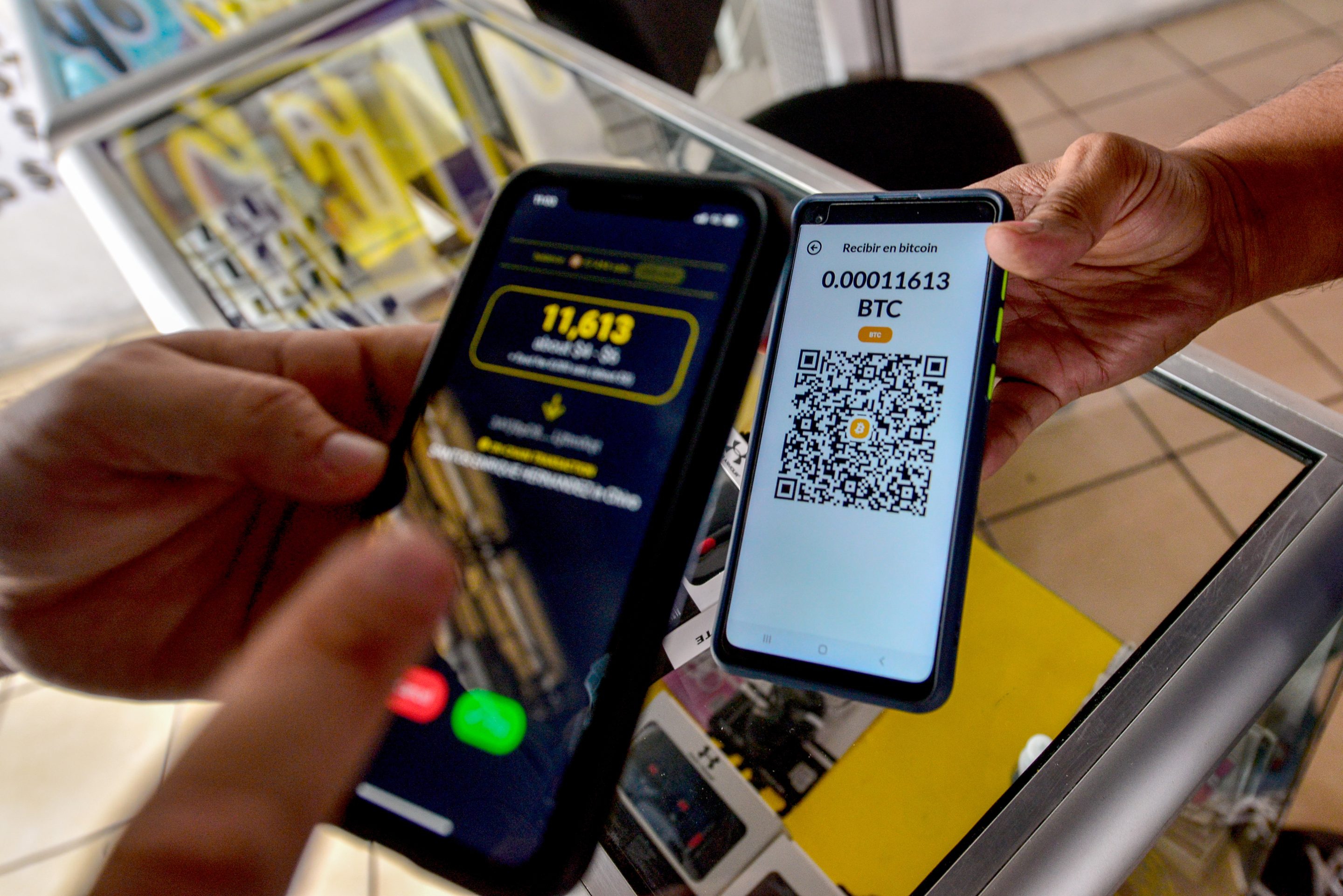A customer pays with Bitcoin at a cell phone accessories shop in San Salvador on Sept. 30, 2021. A new report by JPMorgan said Bitcoin is increasingly replacing gold as an inflation hedge for institutional investors.