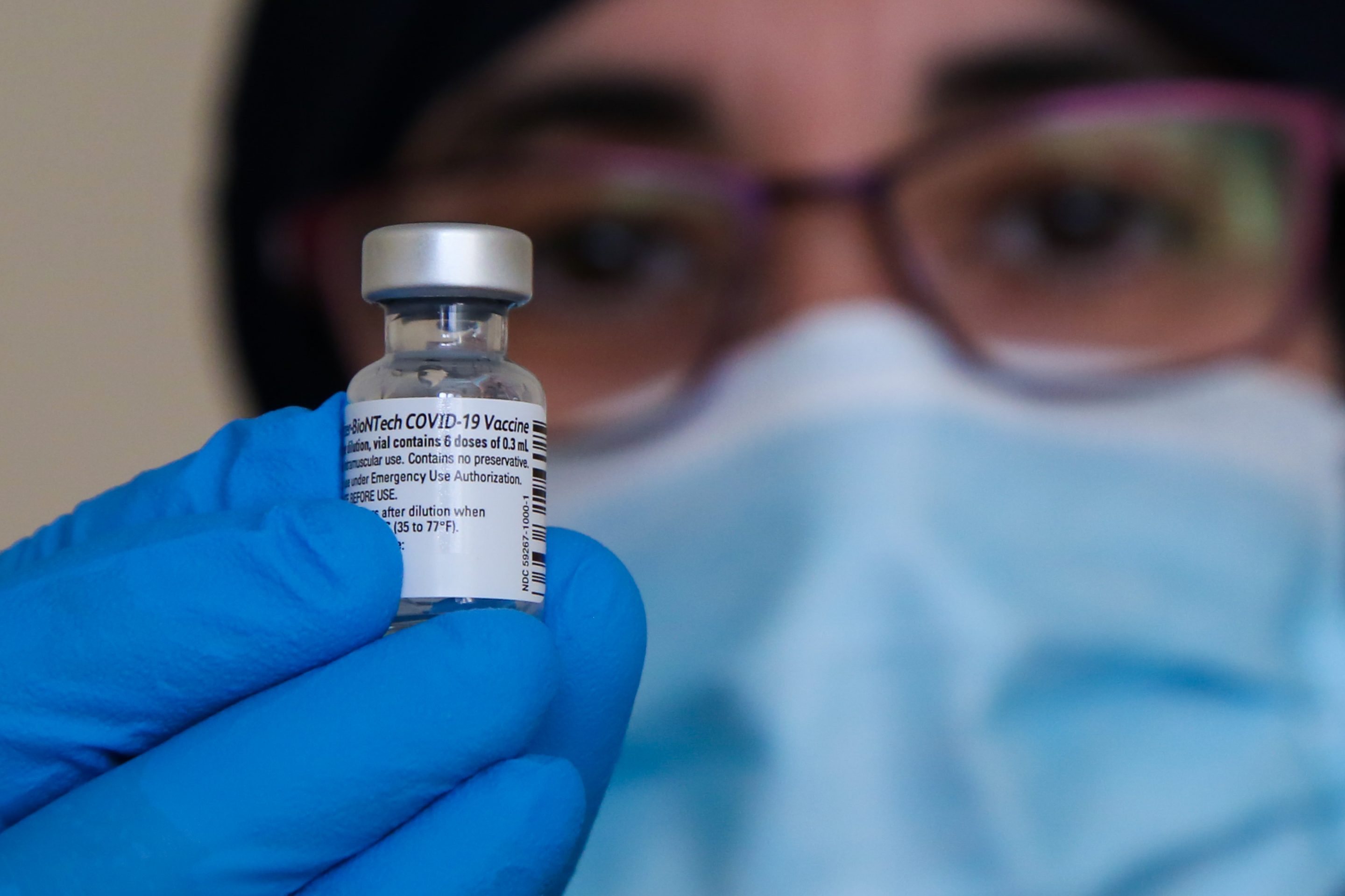 A health worker holds a vial containing Pfizer COVID-19 vaccine at a British vaccination centre.