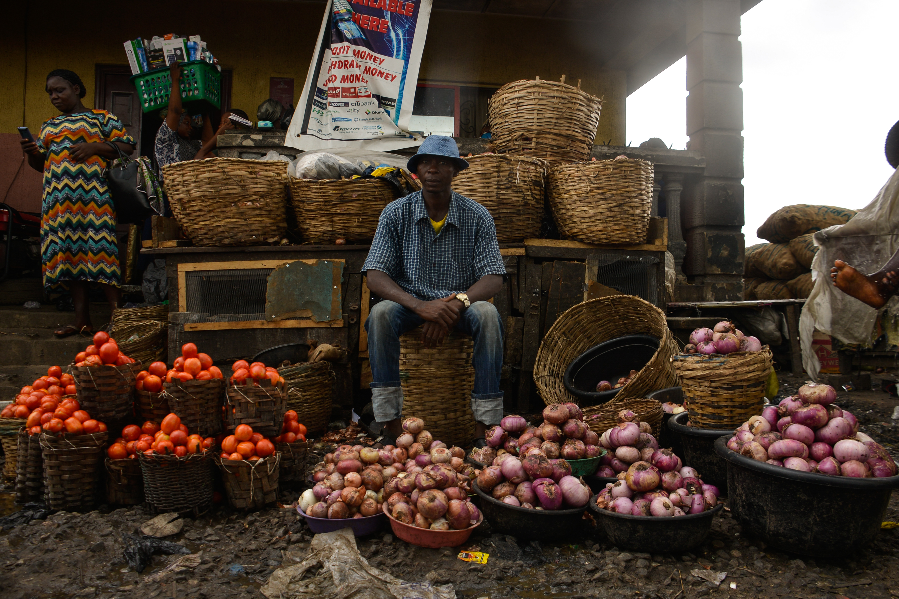 A man sells tomatoes and onions at Mile 12 market in Lagos. Food prices are rising globally.