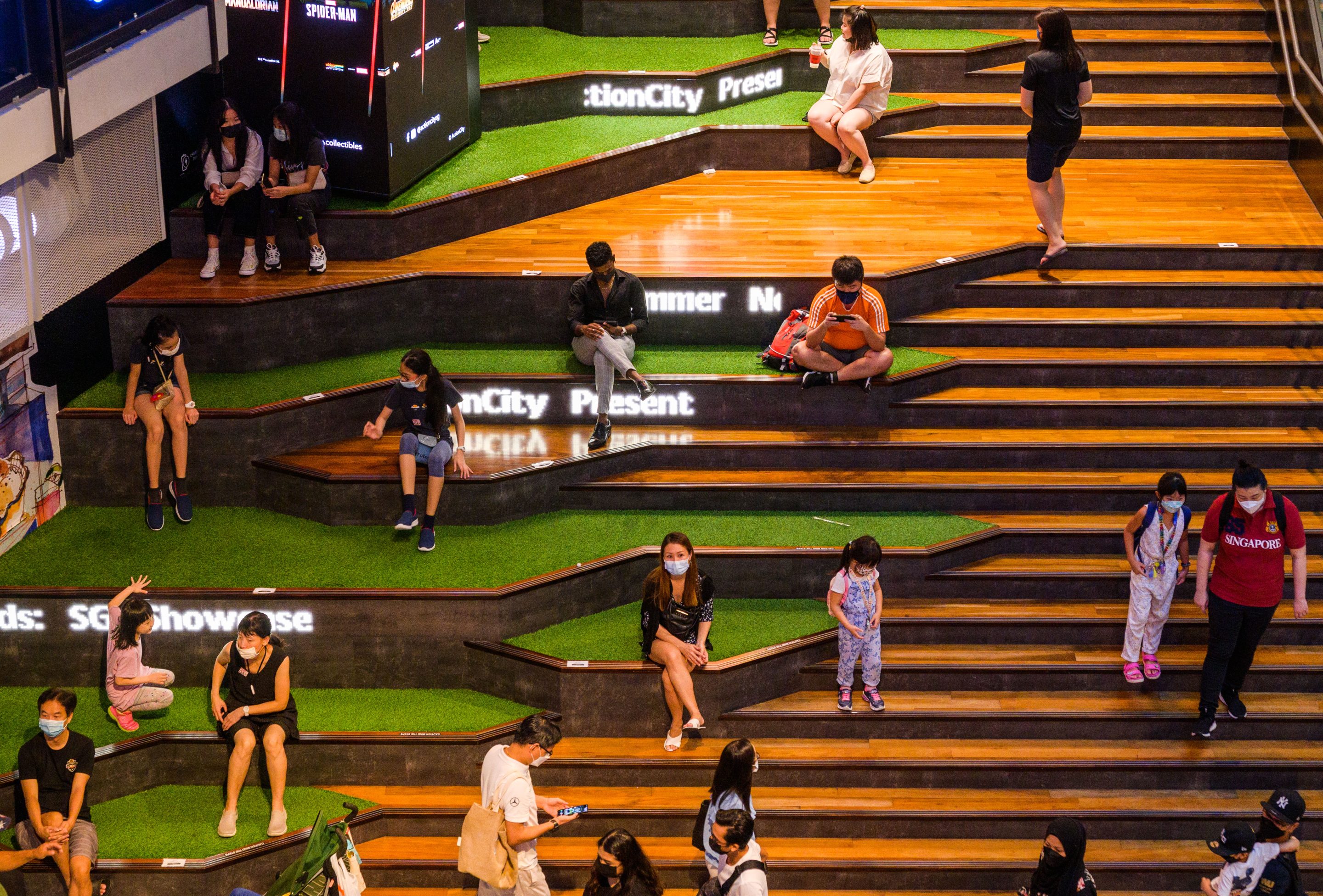 People rest in a seating area marked for safe distancing to prevent COVID-19 virus transmission in a shopping mall in Singapore on Oct. 30, 2021.