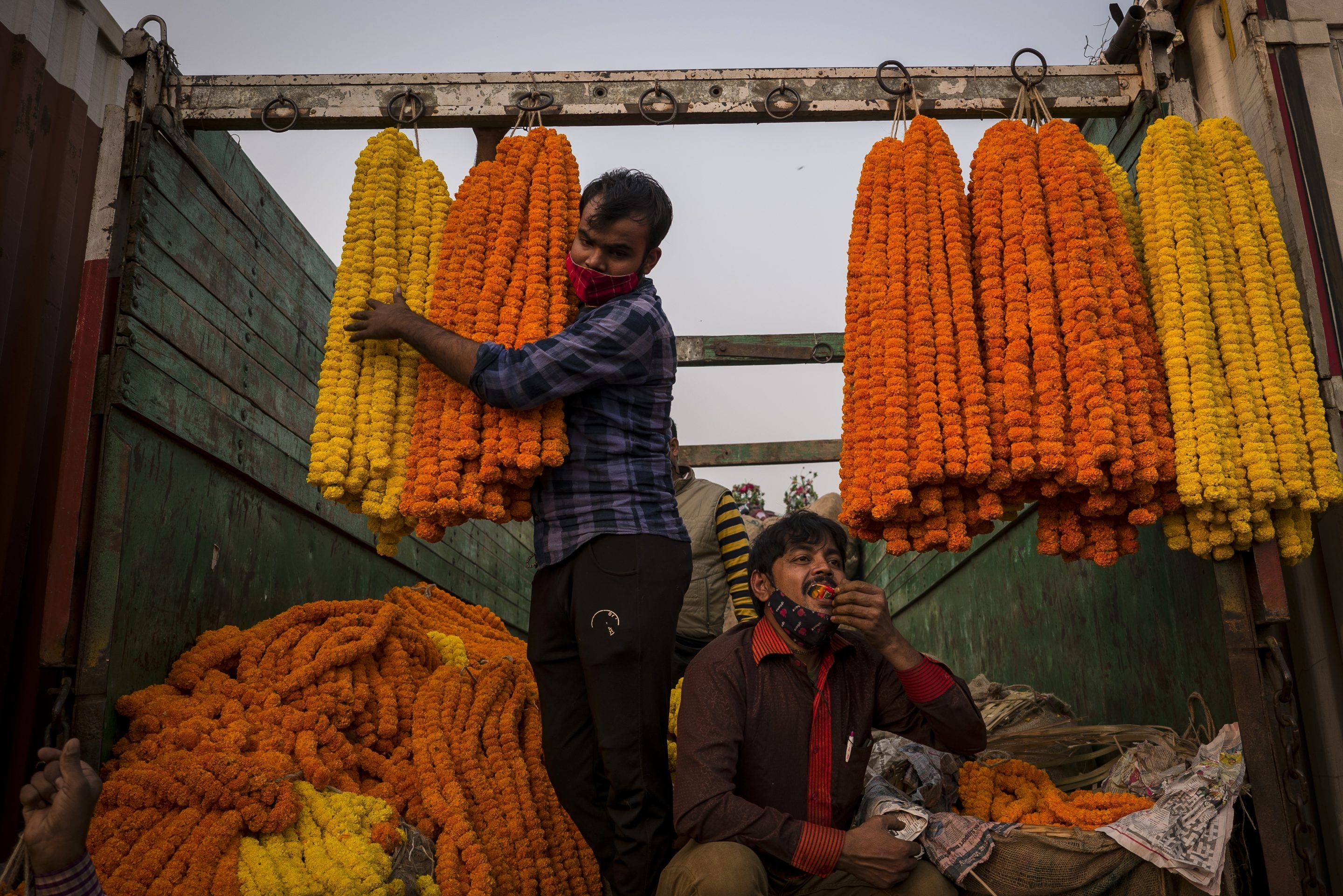 Florists sell marigold garlands from the back of their trucks at a wholesale flower market along a highway during Diwali in Ghazipur, Uttar Pradesh, India, on Nov. 4, 2021.