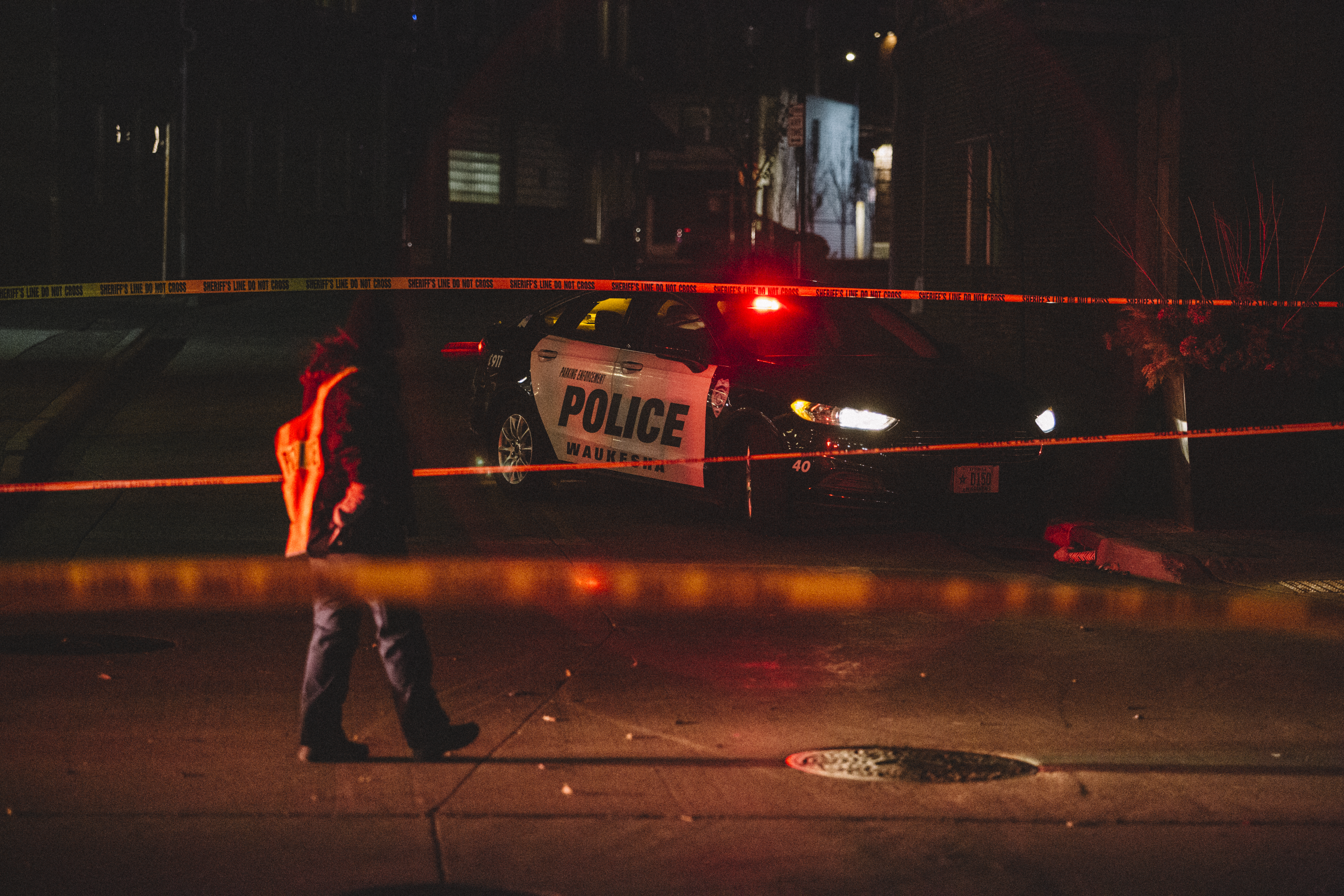 Police and emergency personnel work on a crime scene on Nov. 21, 2021 in Waukesha, Wisc. An SUV drove through pedestrians at a holiday parade, killing at least five.