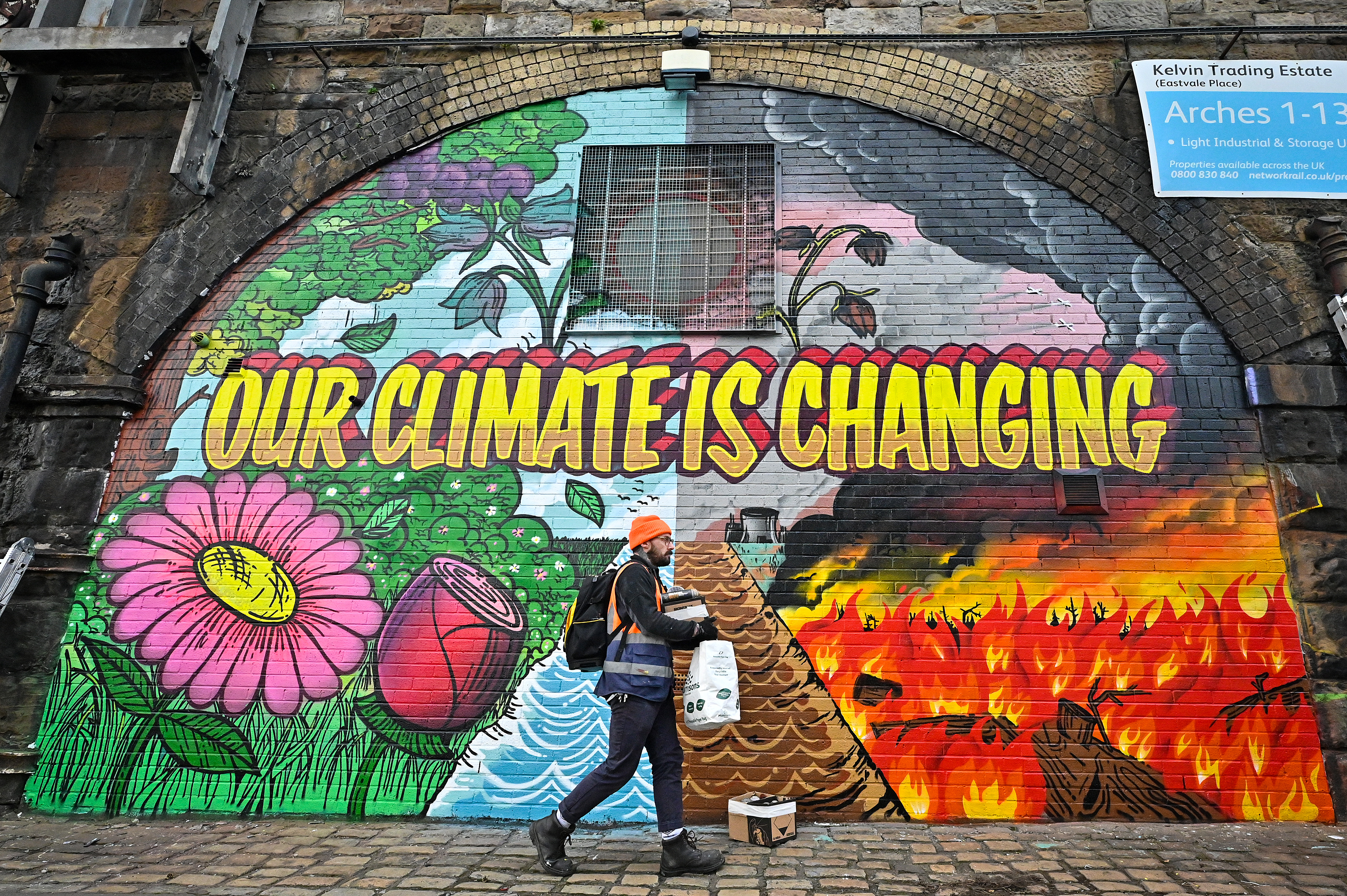 Artists paint a mural on a a wall next to the Clydeside Expressway near the Scottish Events Centre (SEC).