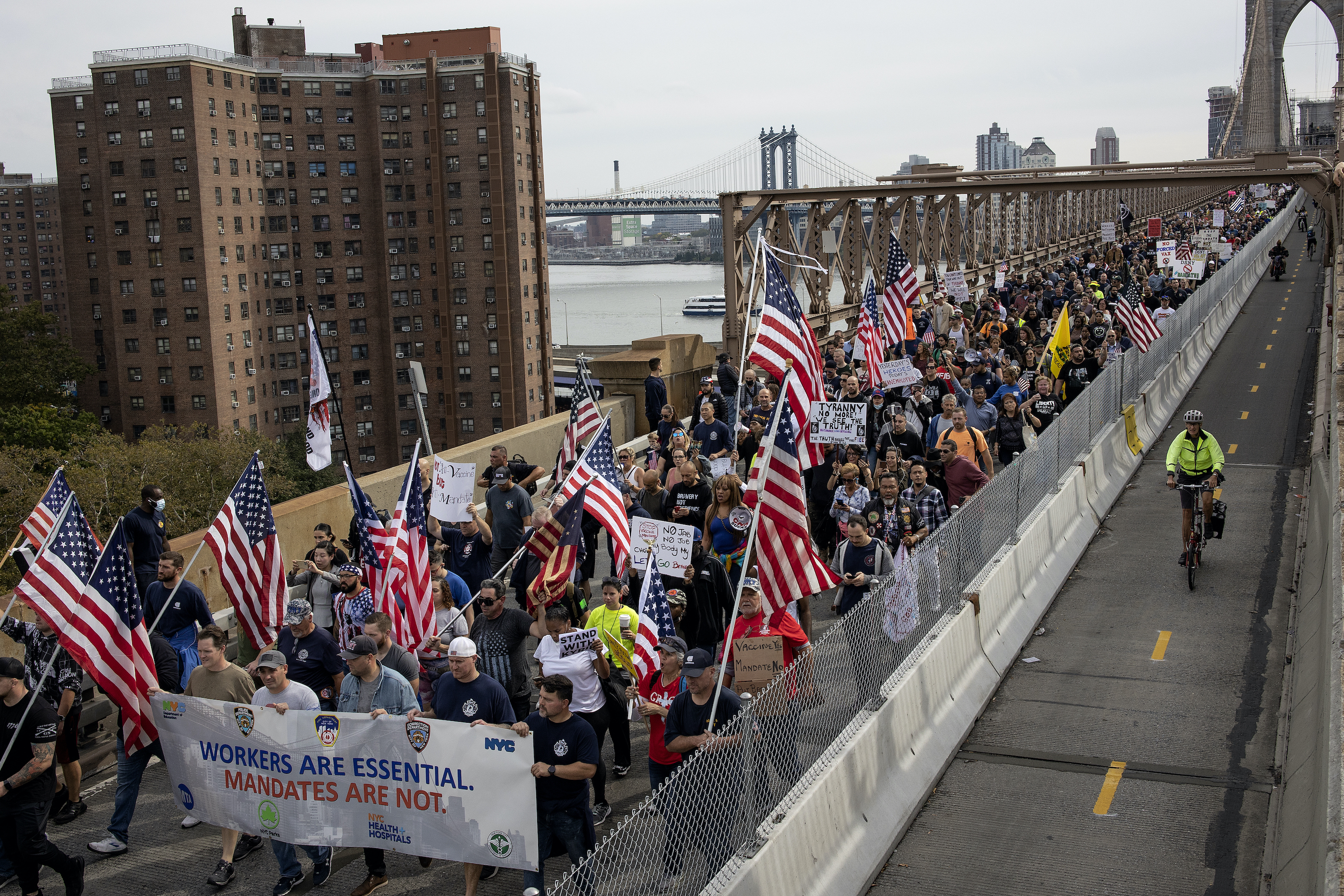 New York City workers, including thousands of firemen, hold a protest march and rally over the Brooklyn Bridge to City Hall to voice their opposition to a city mandate to receive the COVID-19 vaccine or loose their jobs, October 25, 2021 in New York City.