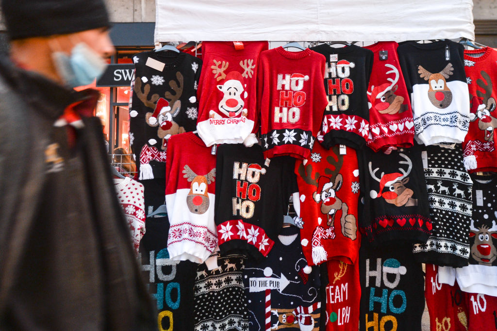A stand with Christmas sweaters seen on a busy street.