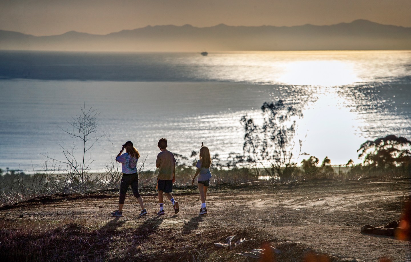 Three hikers enjoy an ocean view in California.