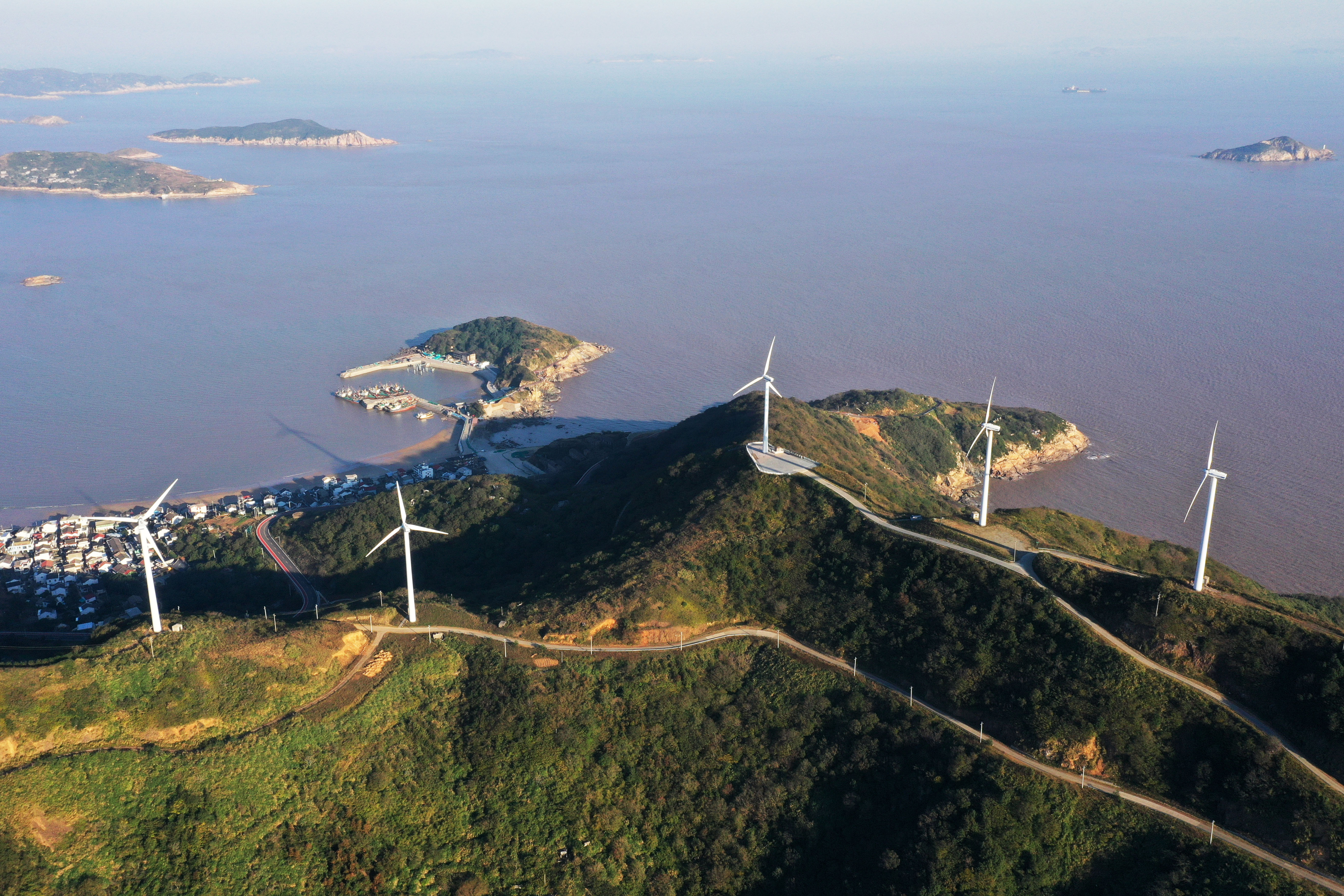 An aerial photo taken on November 24, 2021 shows wind turbines rotating under sea breeze at a wind farm in Zhoushan City, Zhejiang Province, China.