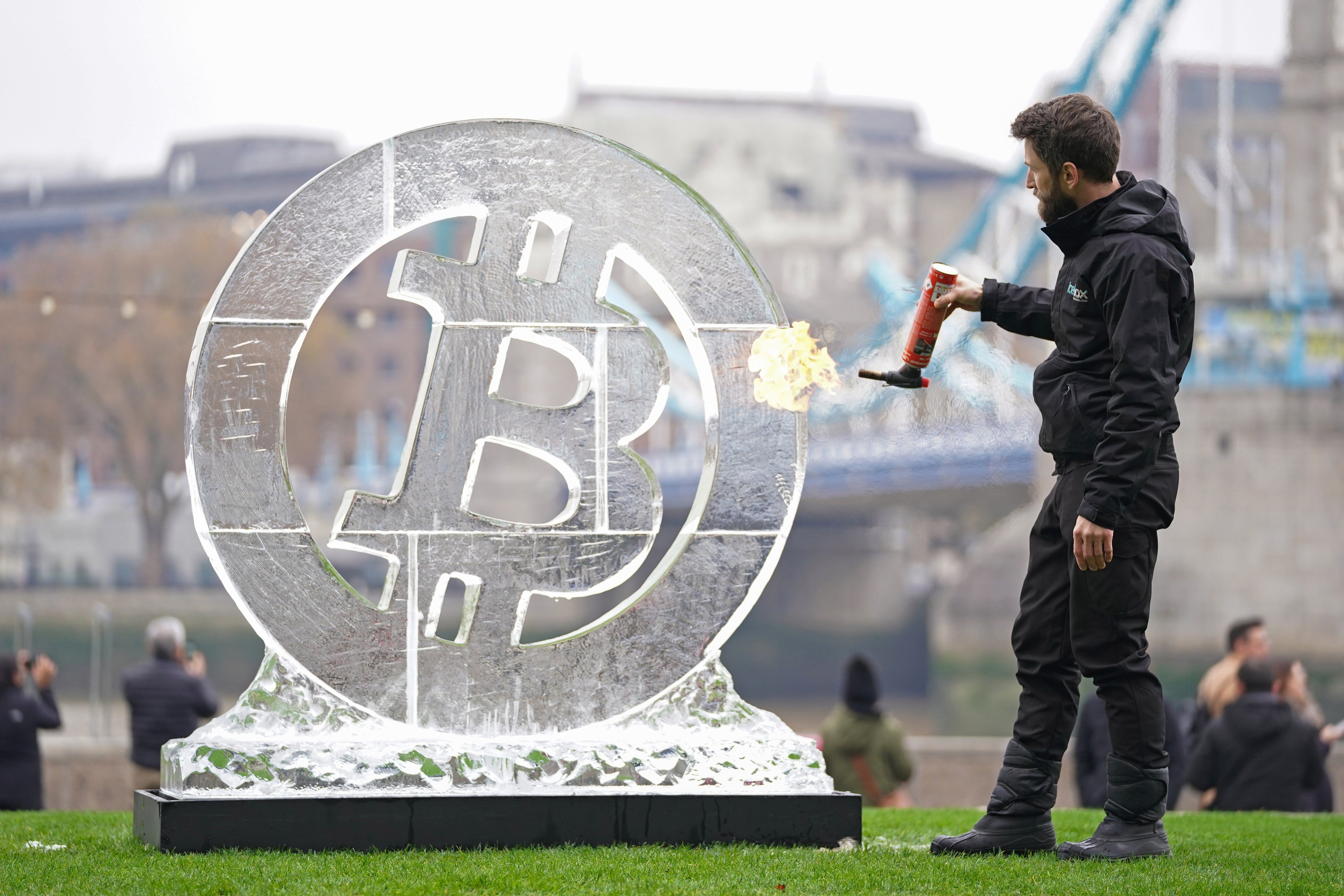 Ice Sculptor Csaba Vass puts the finishing touches to a large Bitcoin ice carving in front of Tower Bridge in London, on Nov. 24, 2021.