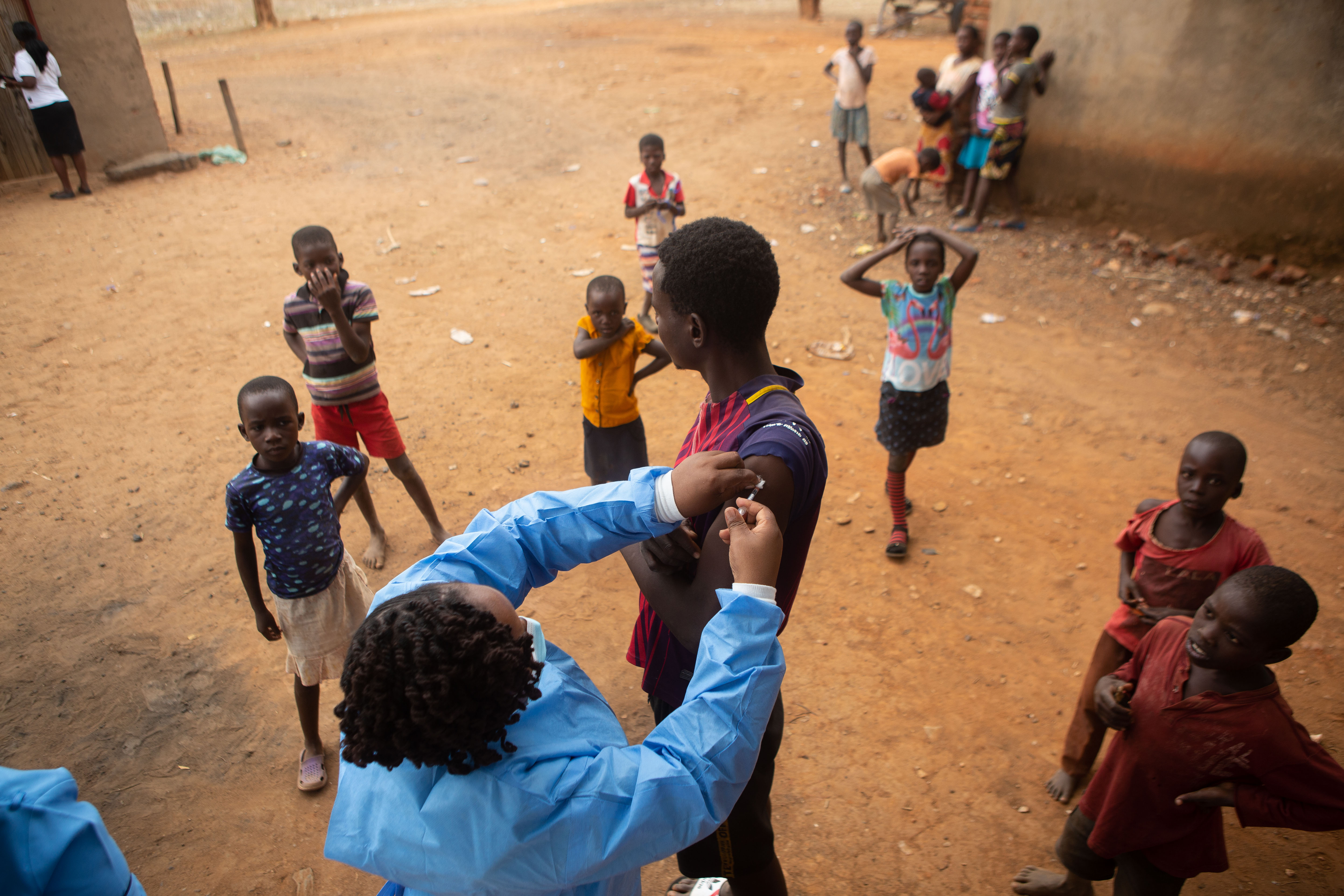 A teenage boy get his first vaccination dose of Sinopharm near Buwi rural area on December 15, 2021 in Chinhoyi, Zimbabwe. As wealthy nations hoard vaccine supplies, only 5% of the population of low-income countries are inoculated against the virus, and none have executed a booster campaign.