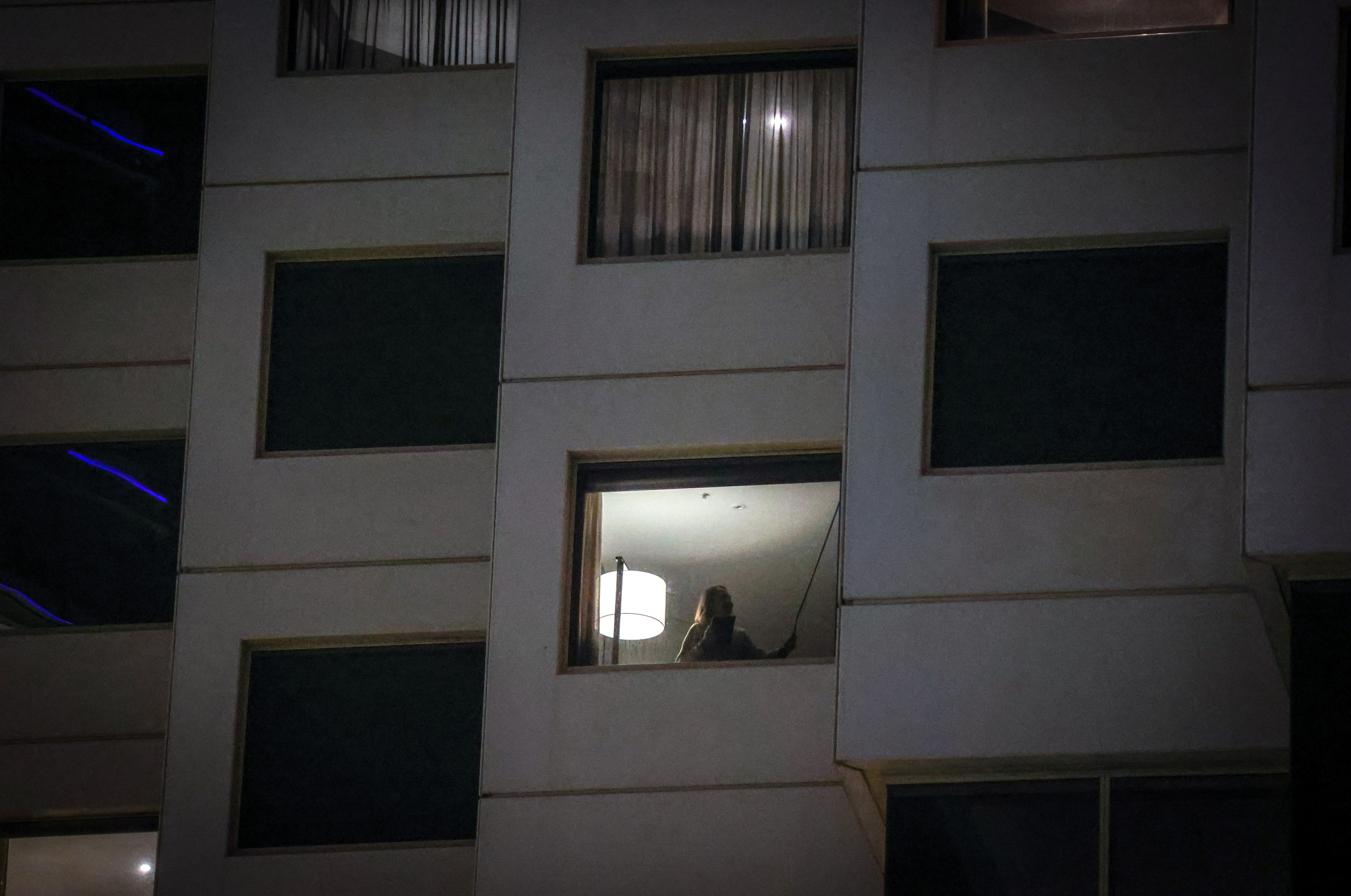 An Australian resident stands in the window of her hotel room during mandatory quarantine as a result of COVID-19 restrictions after arriving from Italy, in Sydney on September 25, 2020, in Australia.
