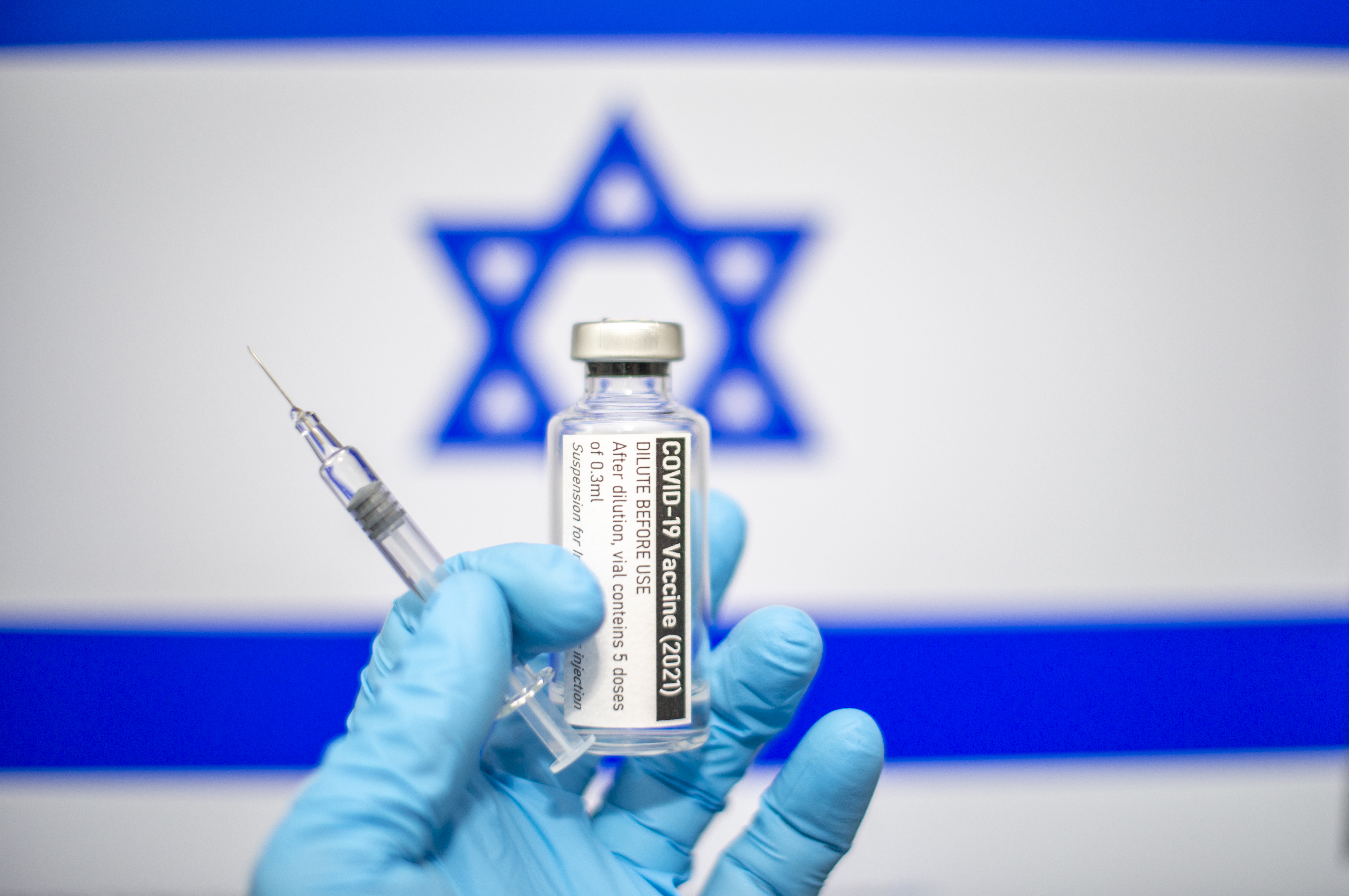 COVID-19 vaccine in front of Israeli flag