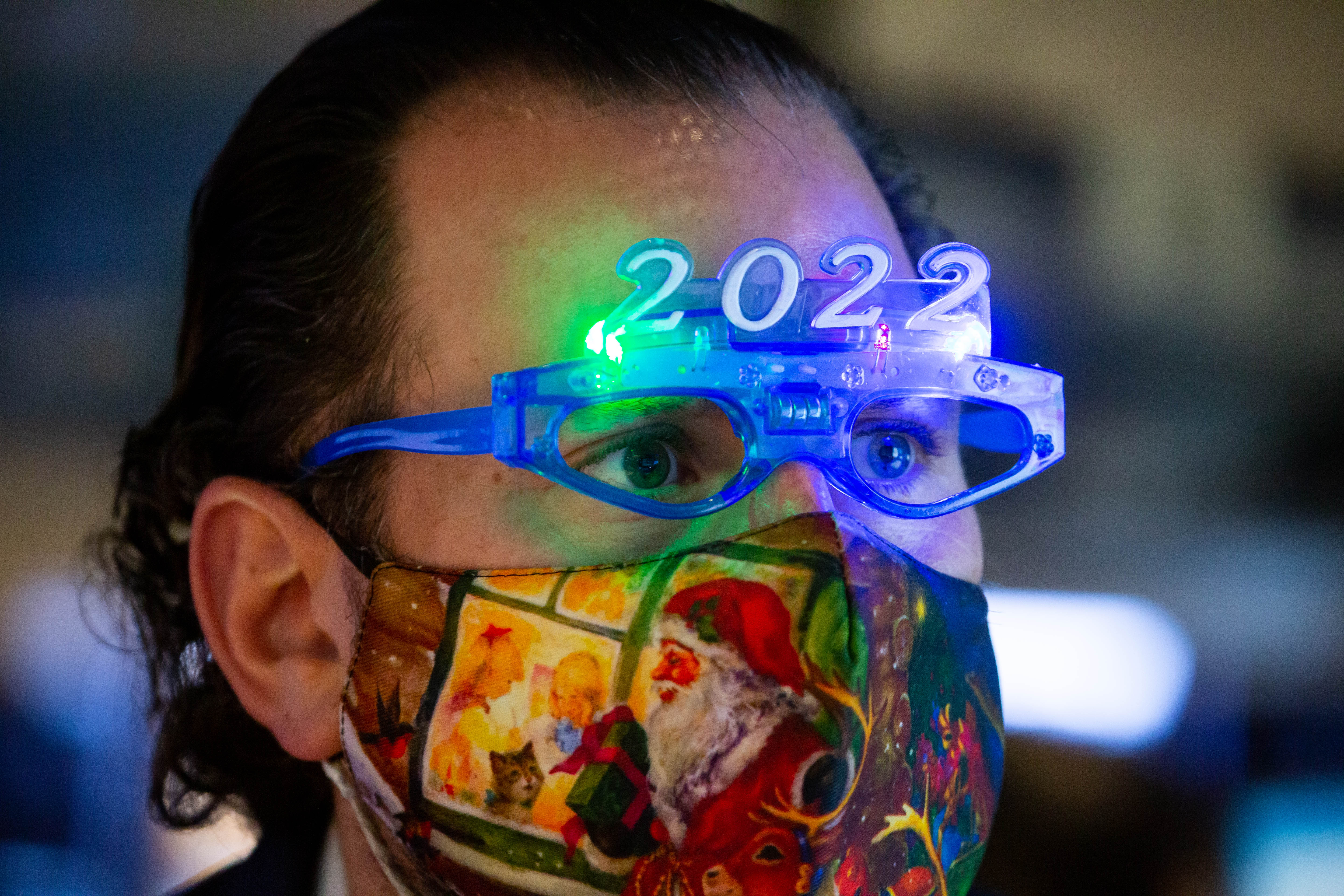 A trader wears 2022 glasses on the floor of the New York Stock Exchange on Dec. 31, 2021. Wall Street is warning that 2022 won’t come close to matching last year’s stellar returns.
