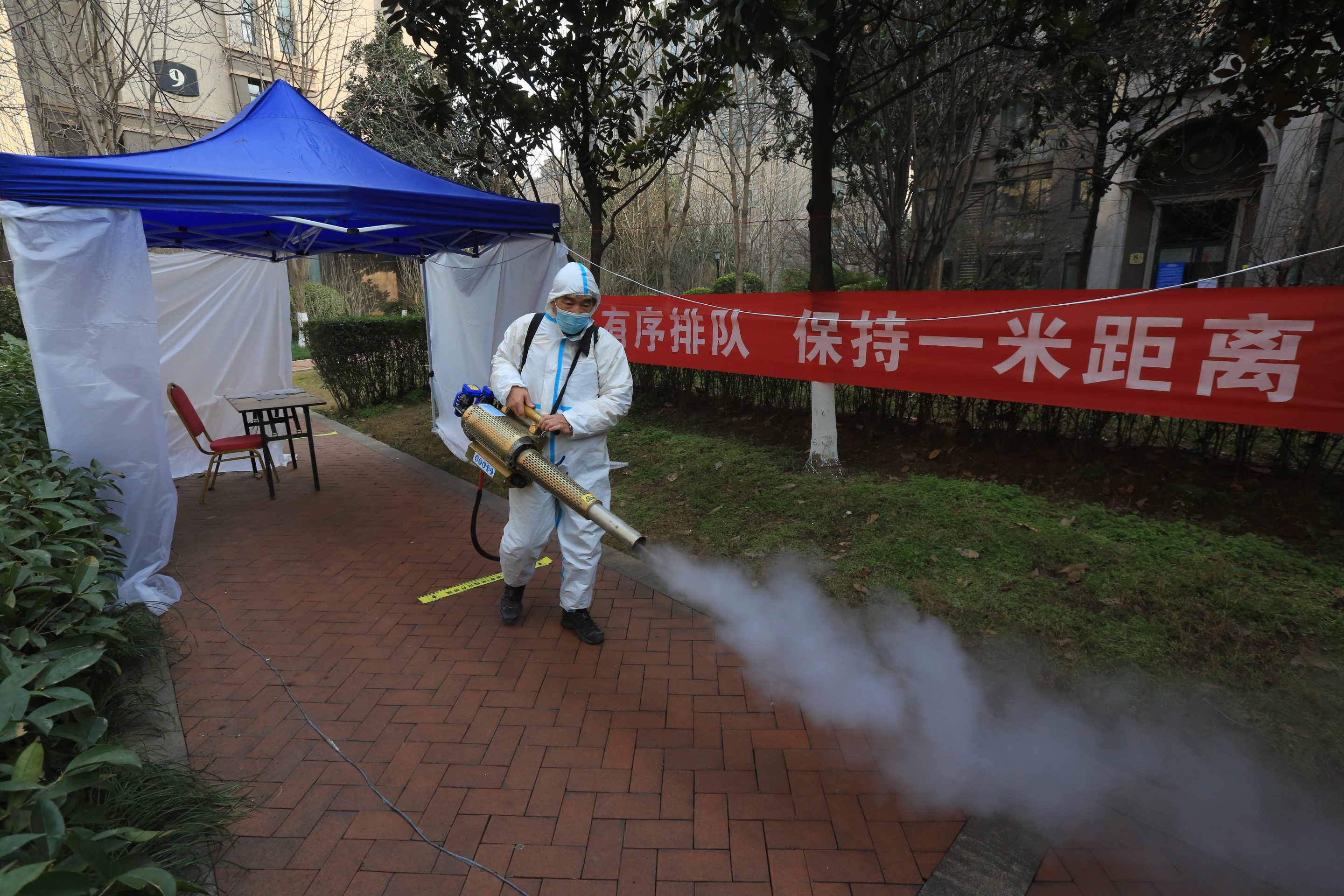 A worker disinfects a garden at a residential block in Xi'an, a city of 13 million people under the COVID-19 lockdown, in Shaanxi province Monday, Jan. 10, 2022.