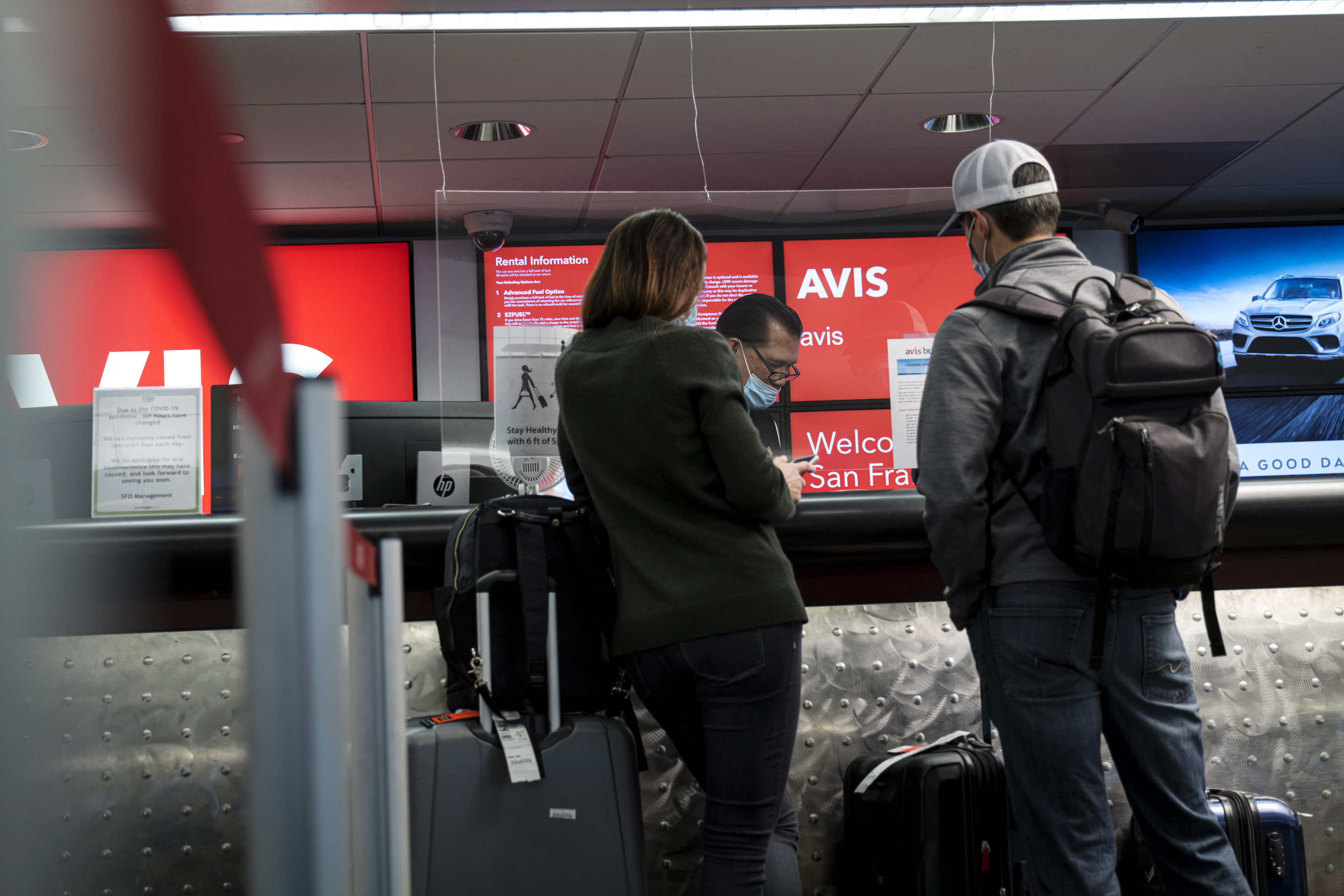 Customers wait at an Avis rental counter