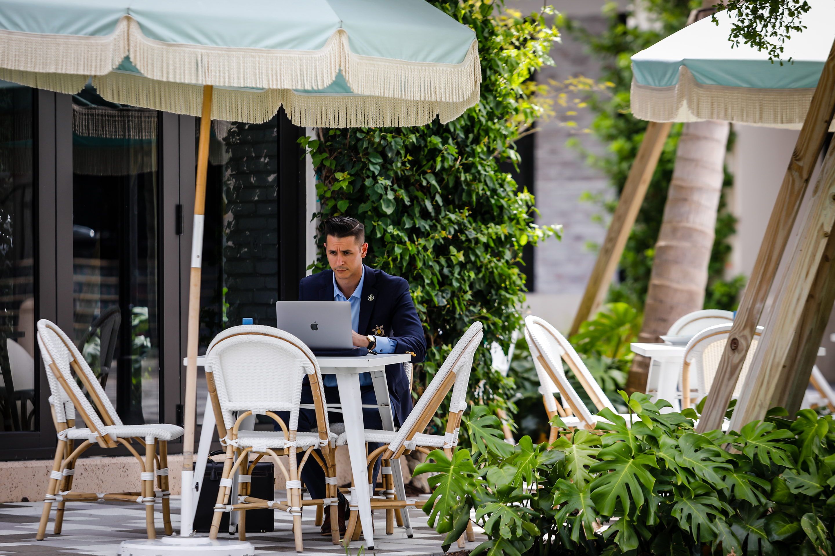 A customer works on a laptop computer in the outdoor dining area of Pura Vida restaurant on Rosemary Avenue in West Palm Beach, Florida.