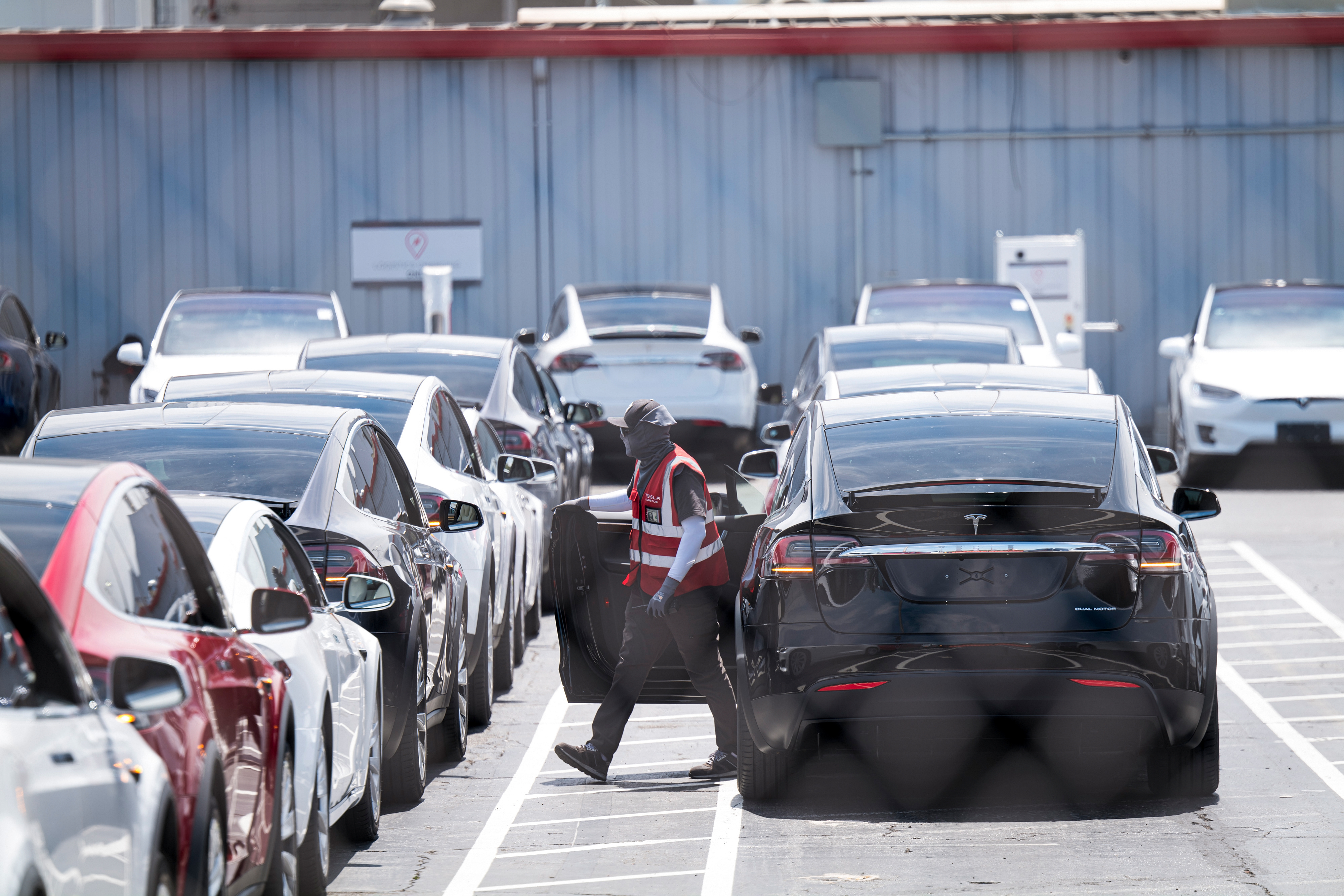 A worker exits a Tesla vehicle at the company's assembly plant in Fremont, Calif., on Aug. 13, 2020. 