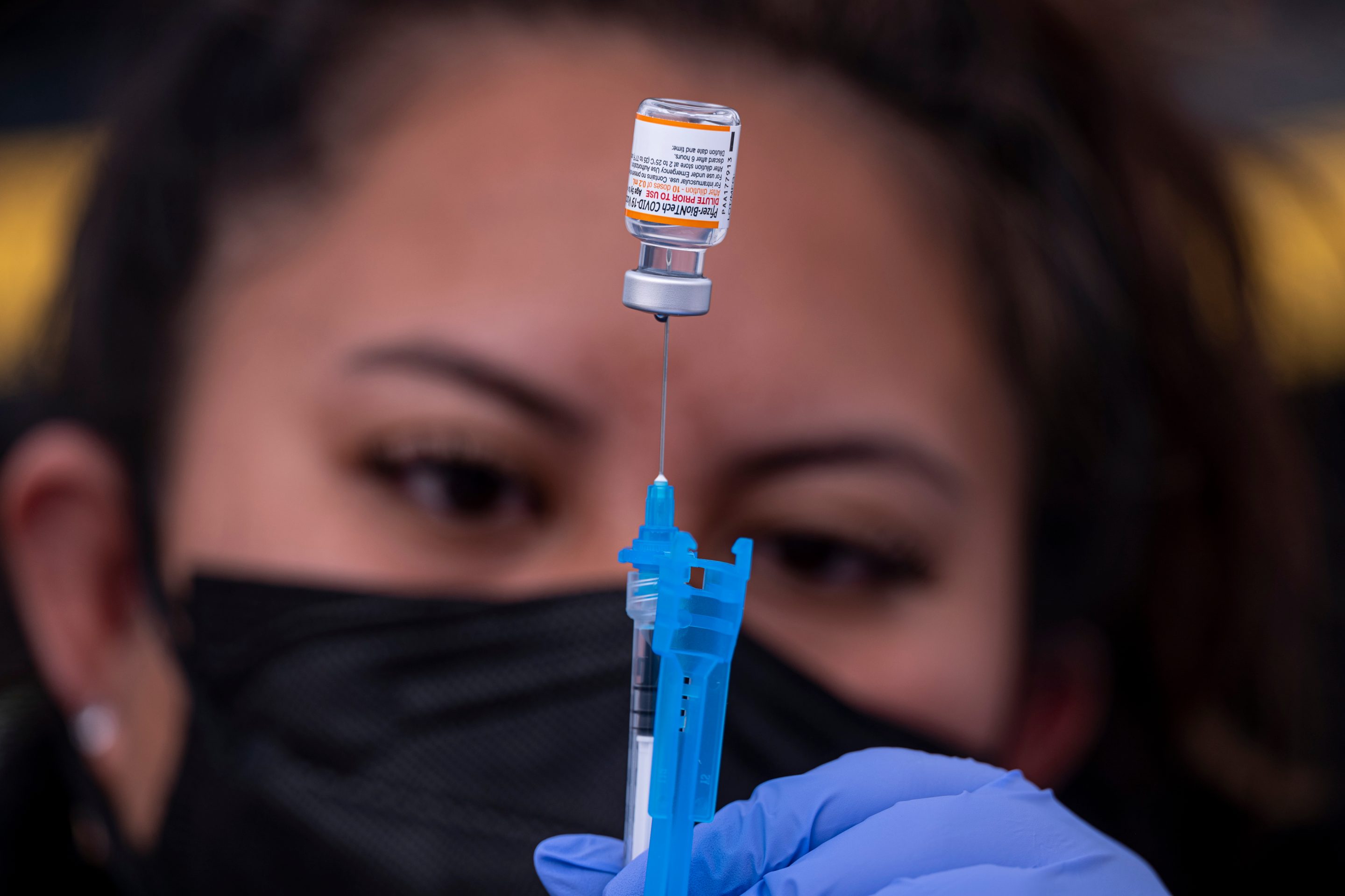 A healthcare worker prepares a dose of Pfizer-BioNTech Covid-19 vaccine at a vaccination site in San Francisco, California on Jan. 10, 2022.